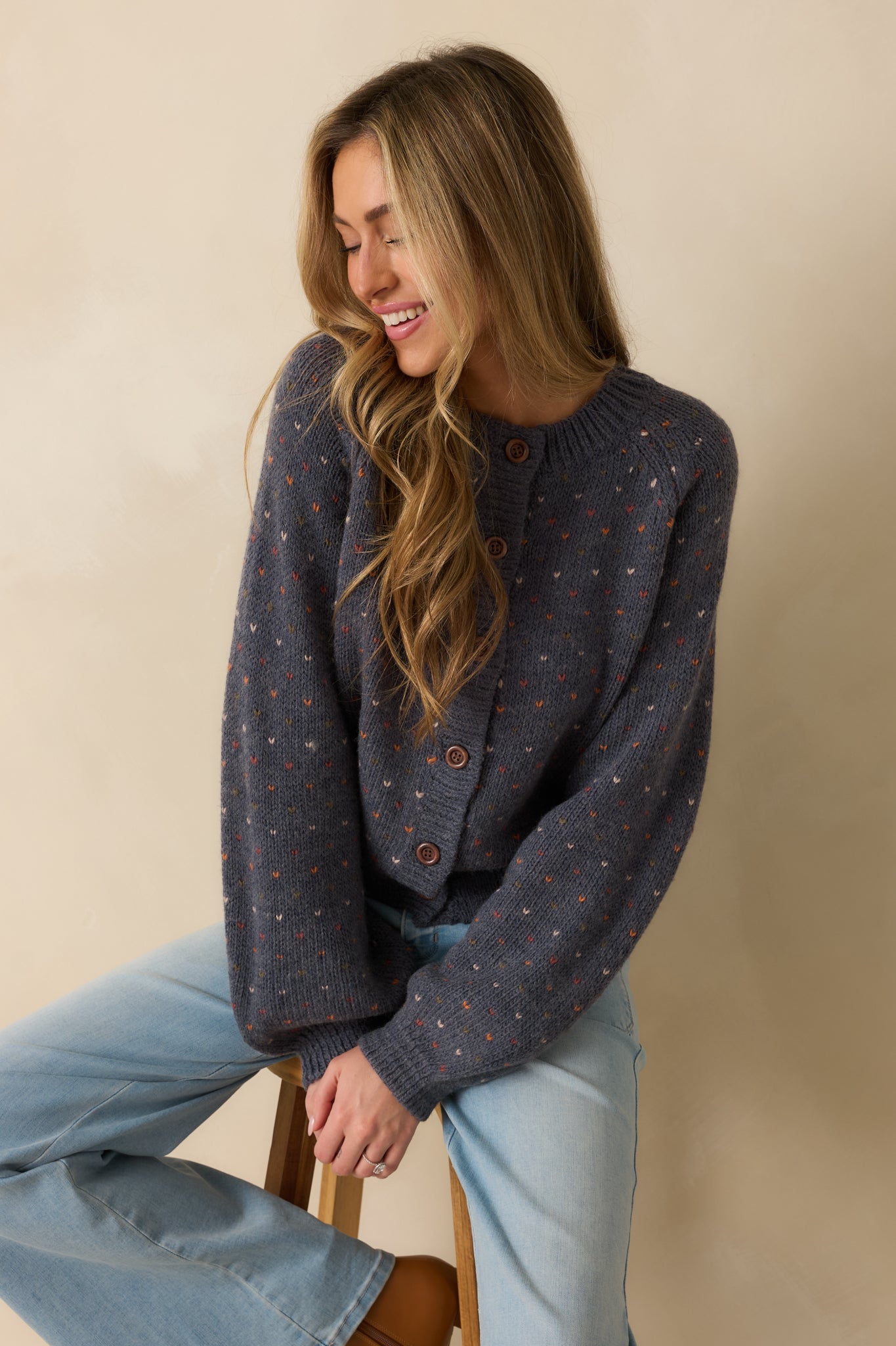 Cropped view highlighting the front button closure and ribbed edges of the cardigan.