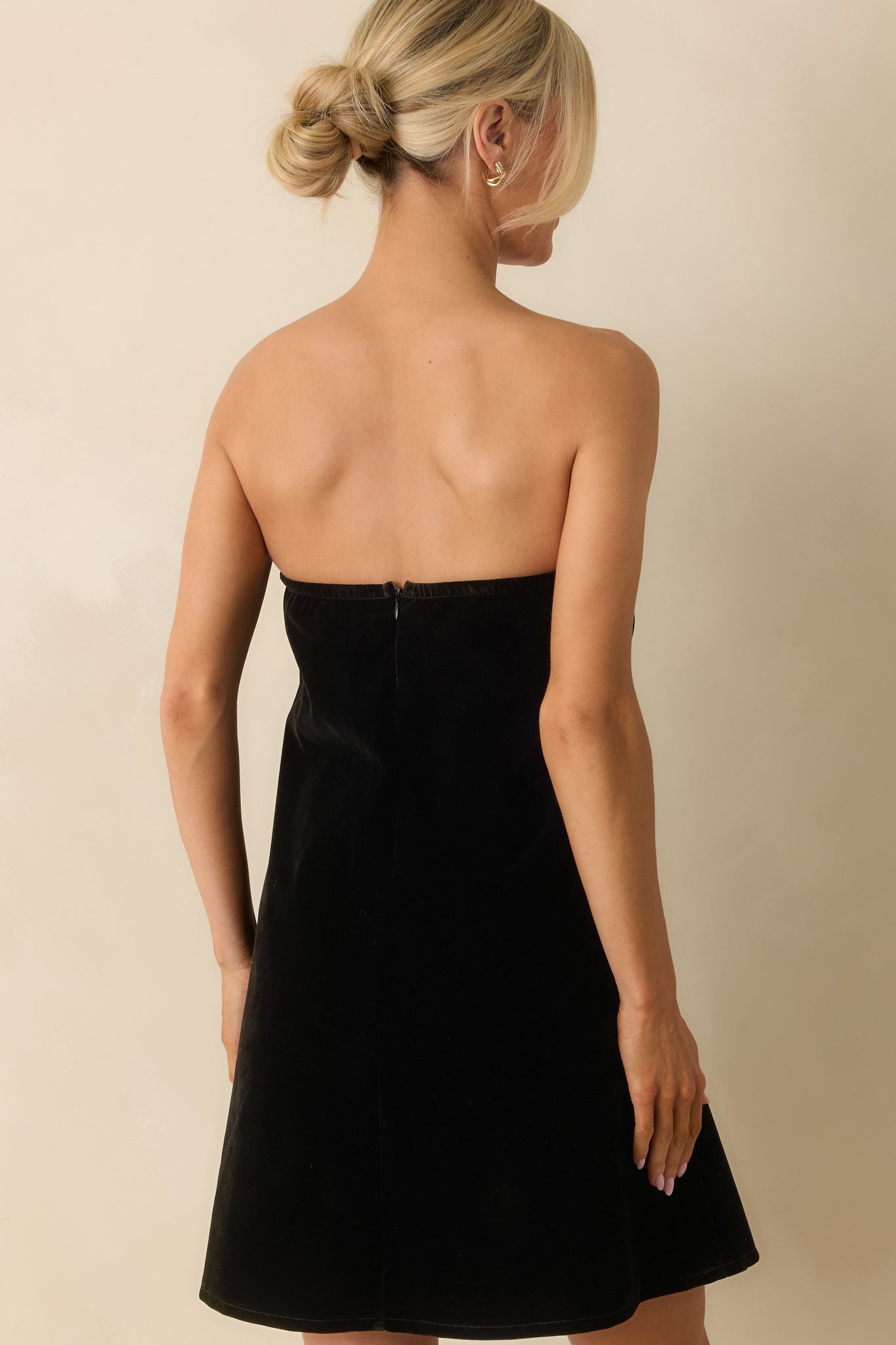 Rear view of the black mini dress displaying a hidden back zipper and smooth lining.