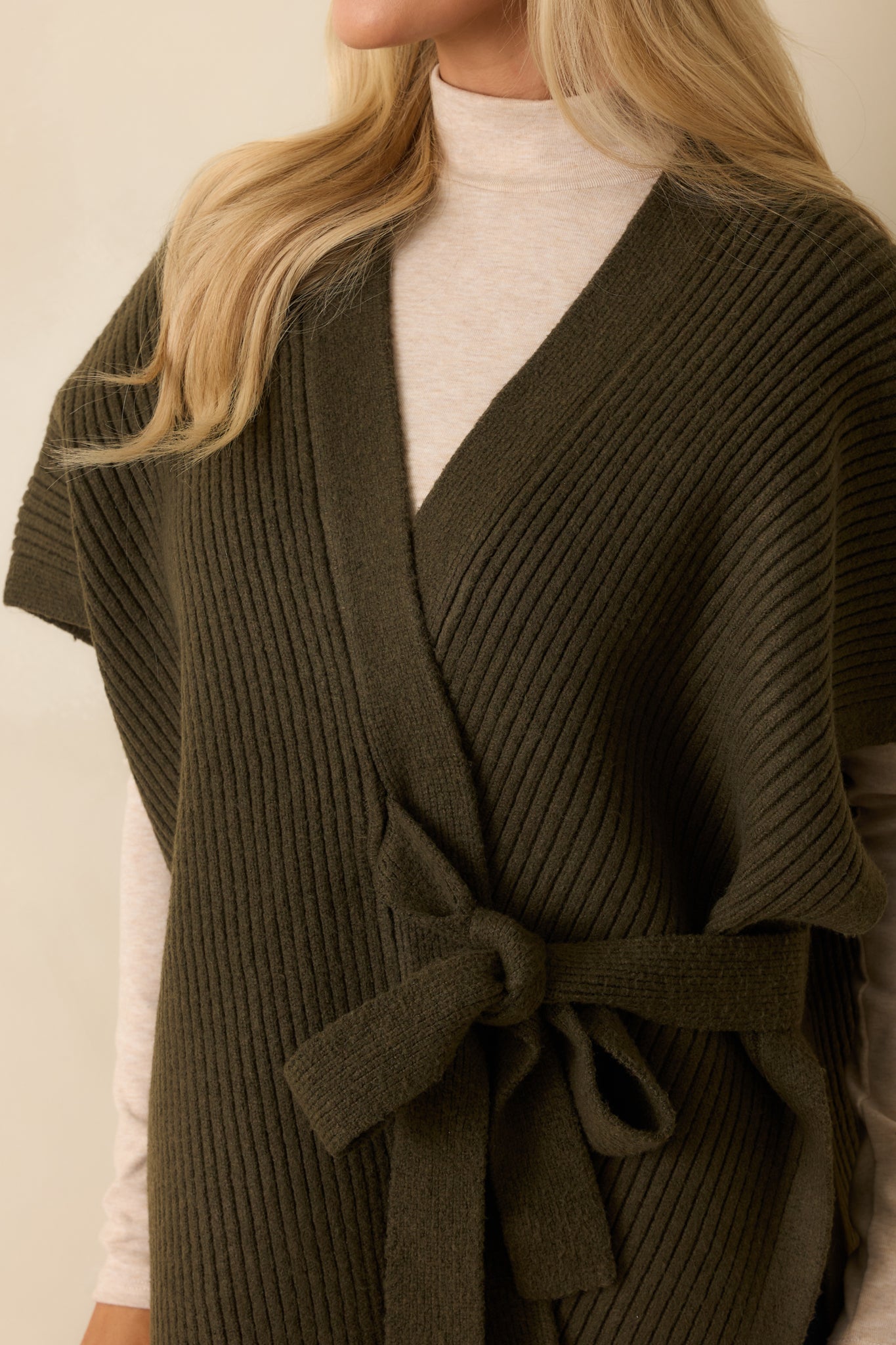 Tight shot of olive green ribbed knit fabric showing texture and soft midweight material.