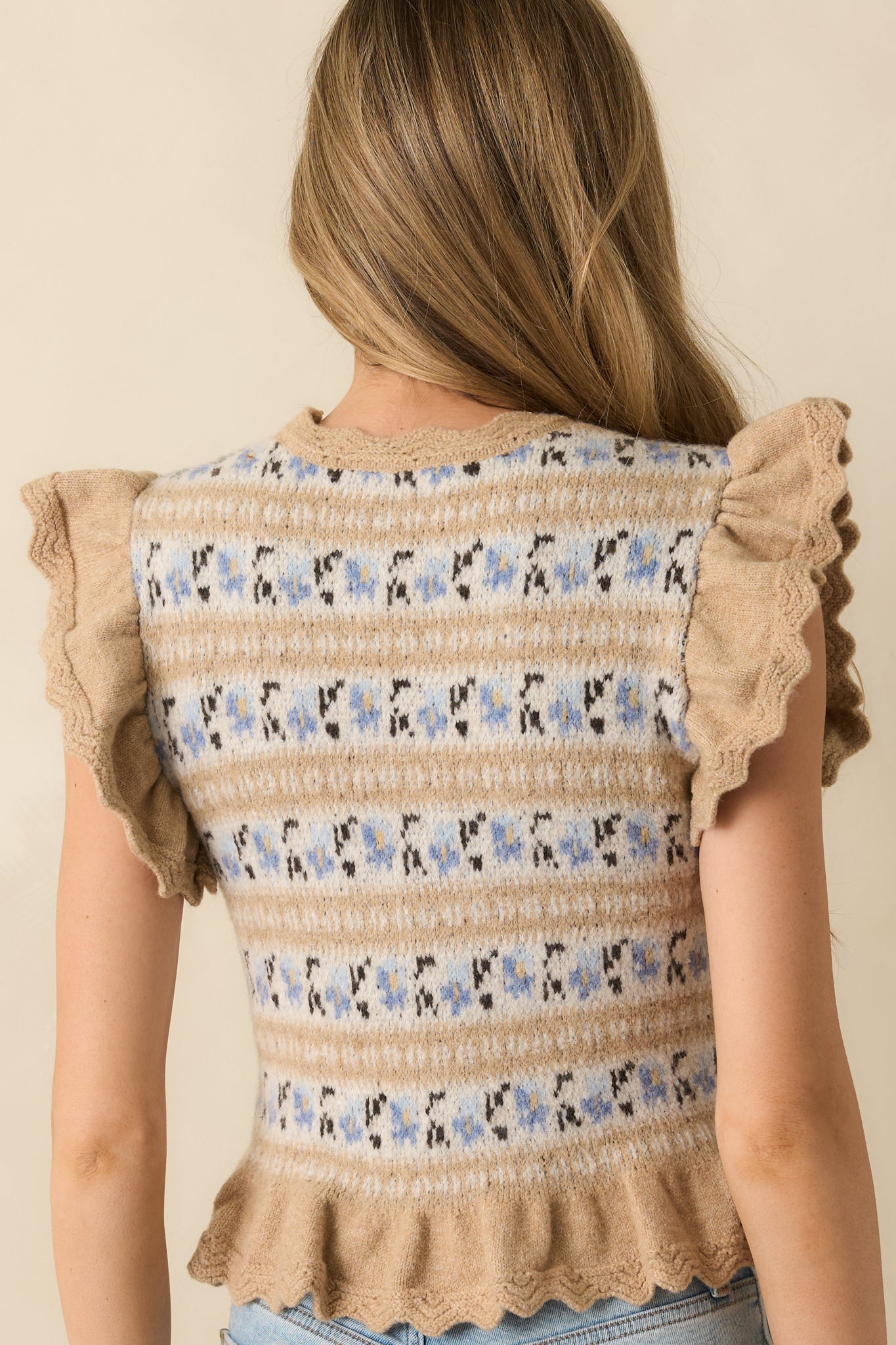 Rear view of the taupe floral knit top displaying smooth knit construction and scalloped hem finish.