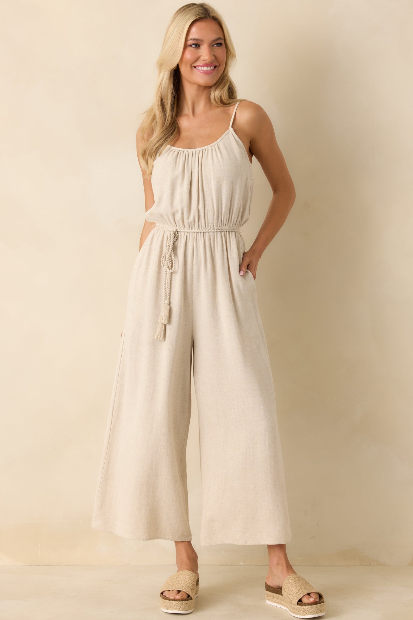 Front-facing jumpsuit displaying functional pockets and flowing wide-leg silhouette.