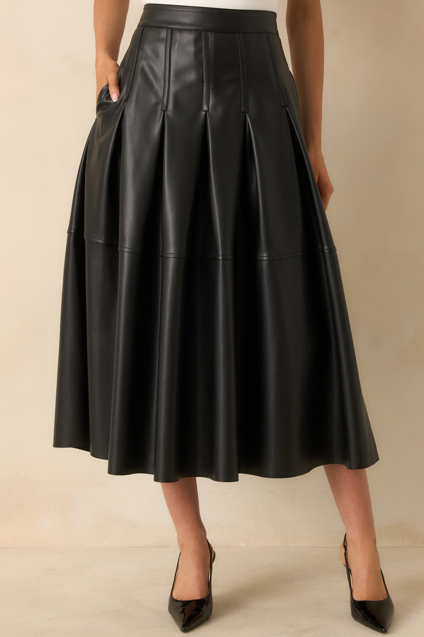 Cropped detail emphasizing the side zipper closure and refined pleated design.