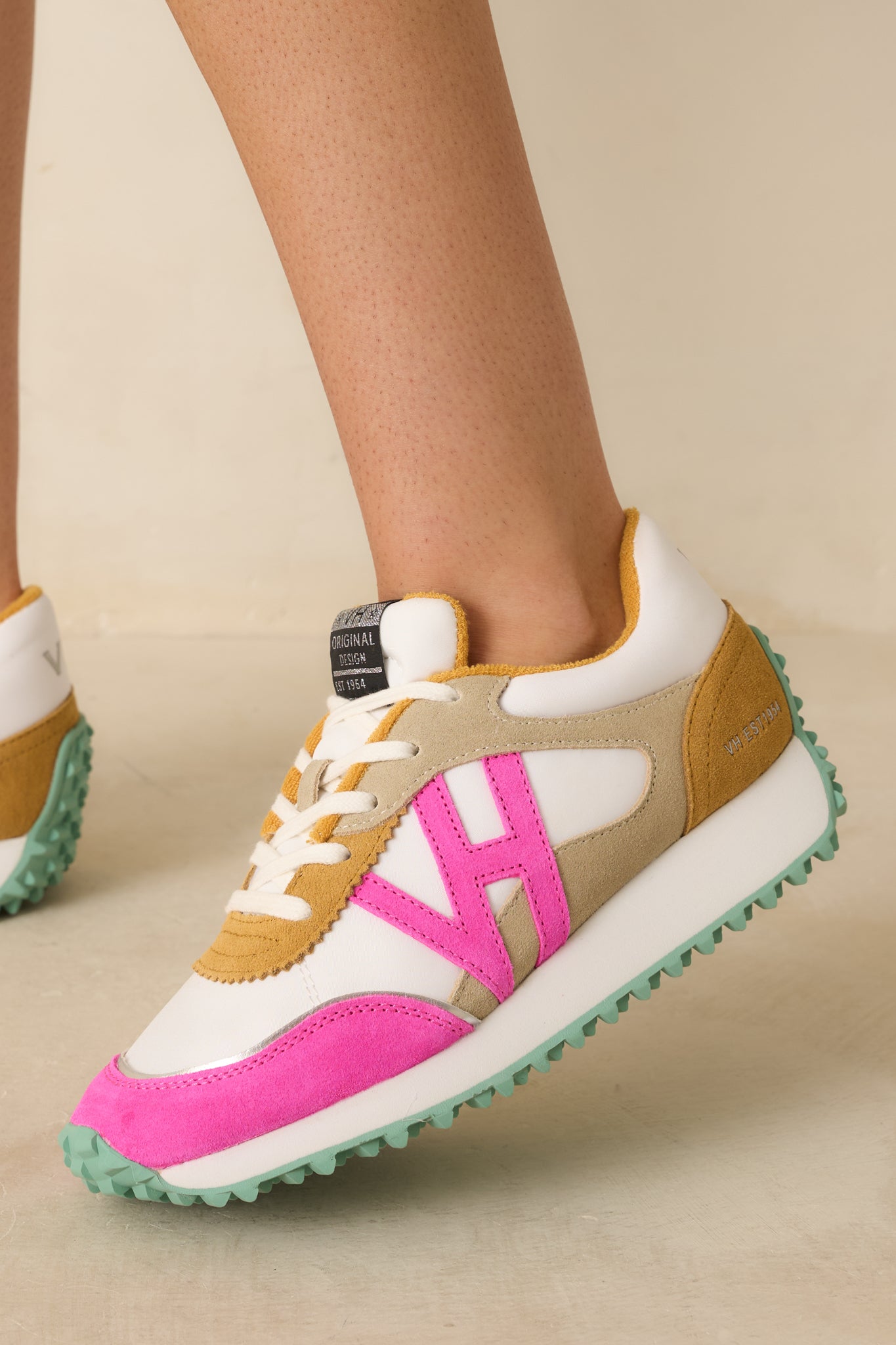 Close-up of the textured outsole and lace area on the sneakers, emphasizing the chunky sole and color accents.