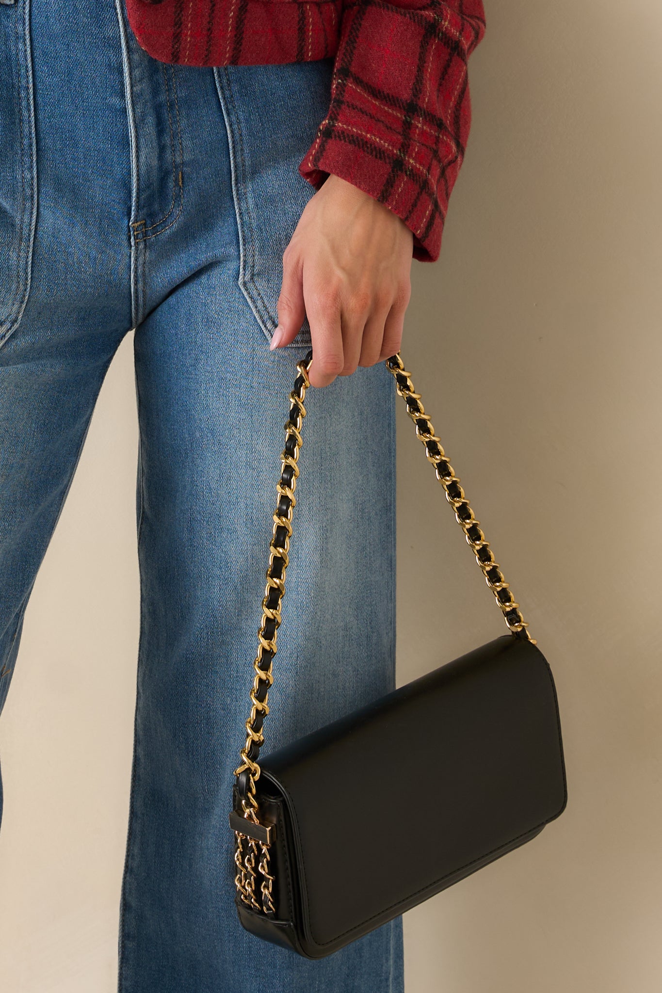 Black faux leather baguette handbag with chain shoulder strap and decorative side chains.