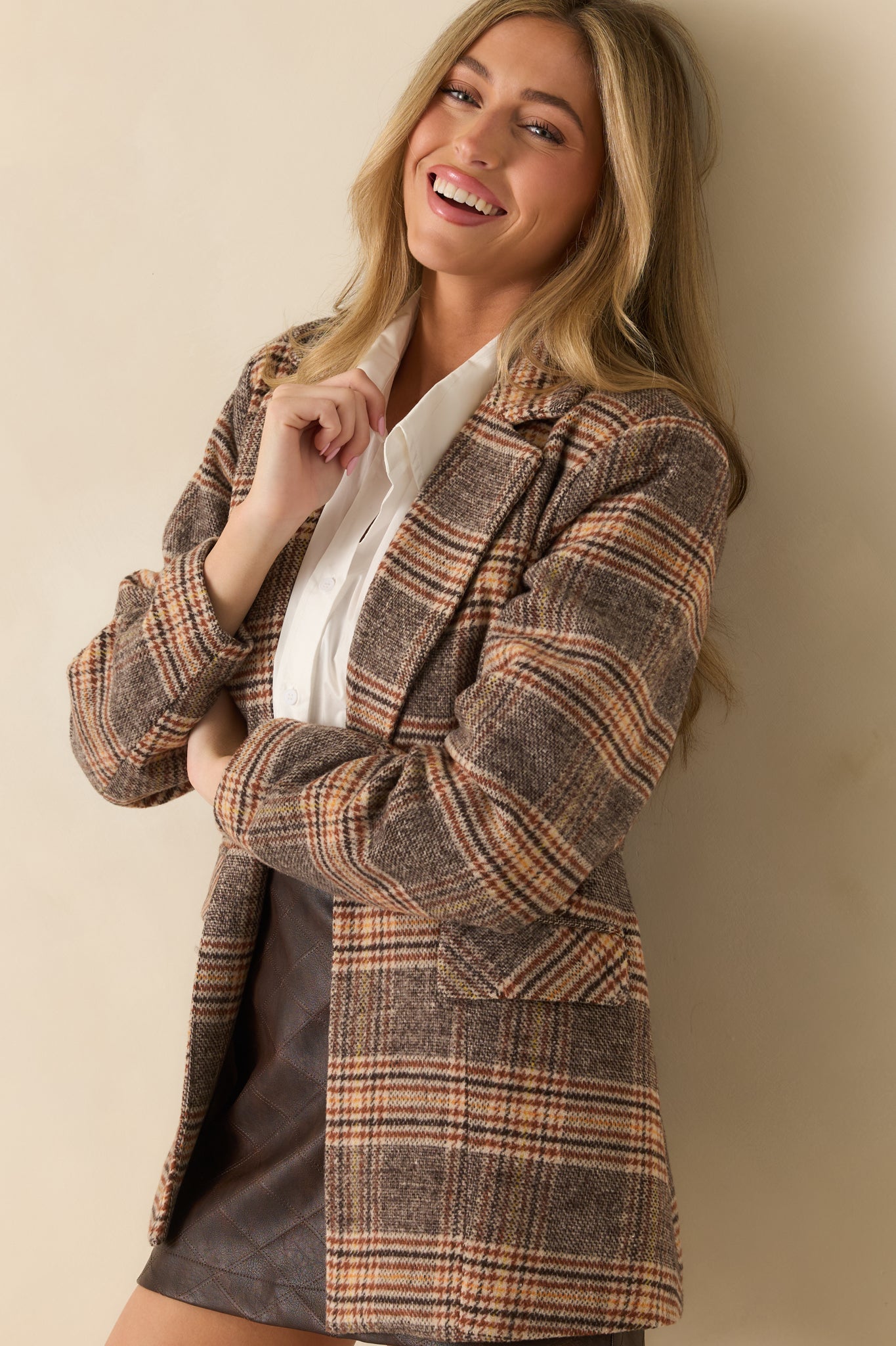 Brown plaid coat designed with a collared neckline, front buttons, and a softly relaxed shape.