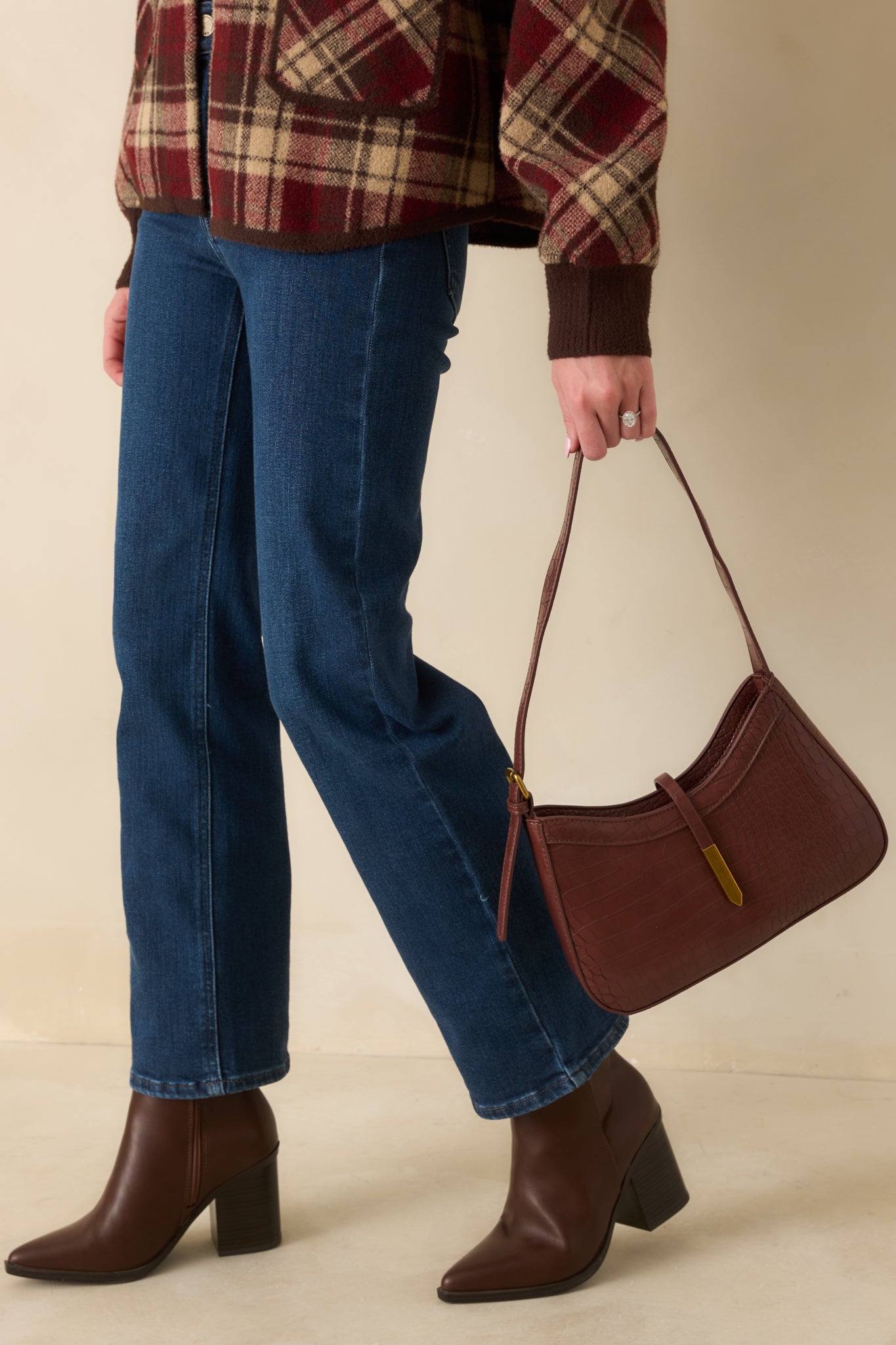 Sleek croc-embossed brown shoulder bag showcasing polished gold hardware and its clean, structured form.