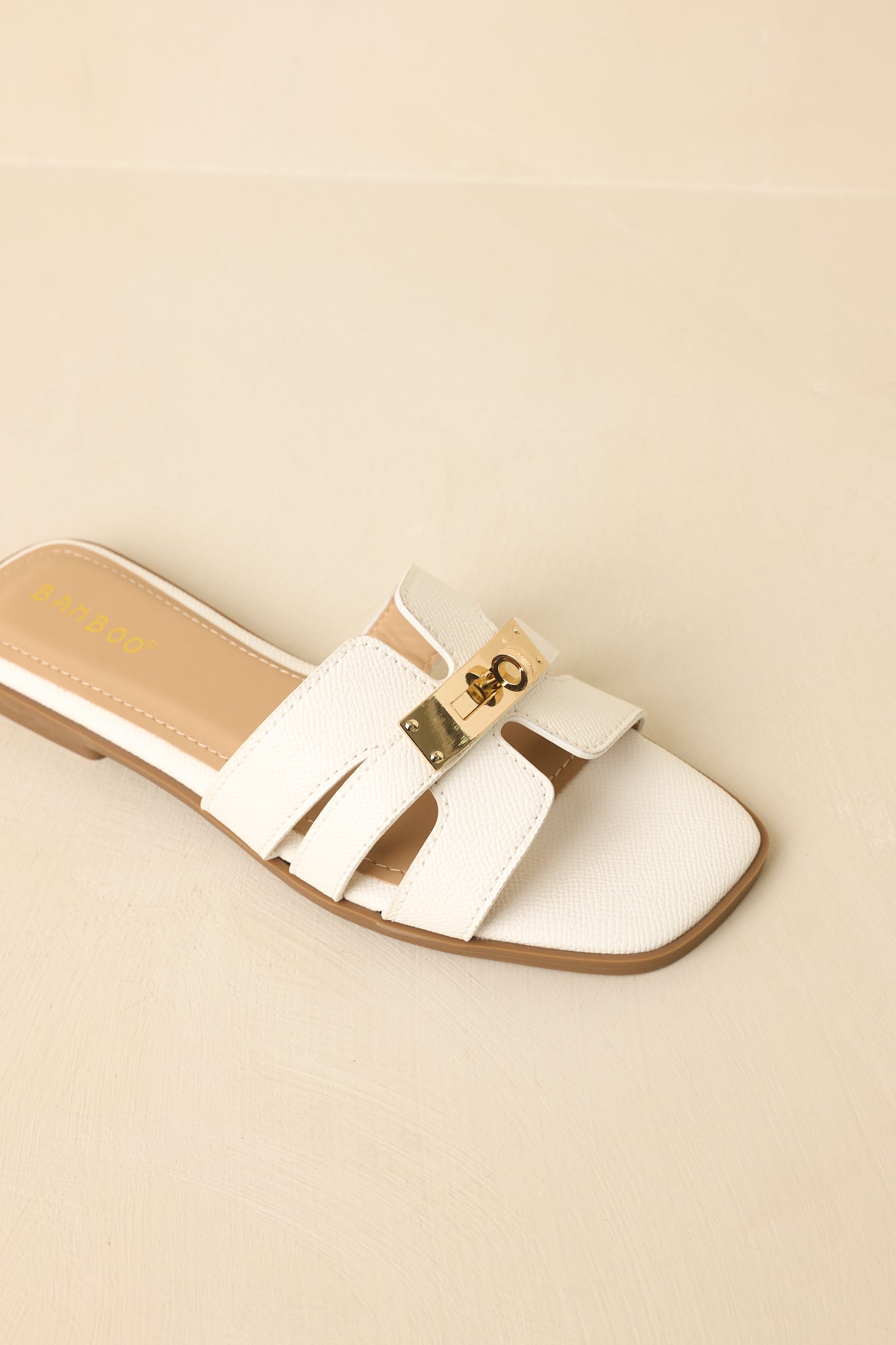Overhead view of sandals displaying textured strap overlay and sleek gold accent.