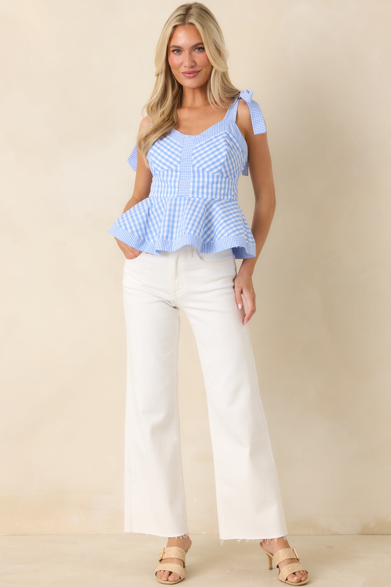 Lightweight gingham peplum blouse with fitted bodice and relaxed flared hem in breathable cotton.