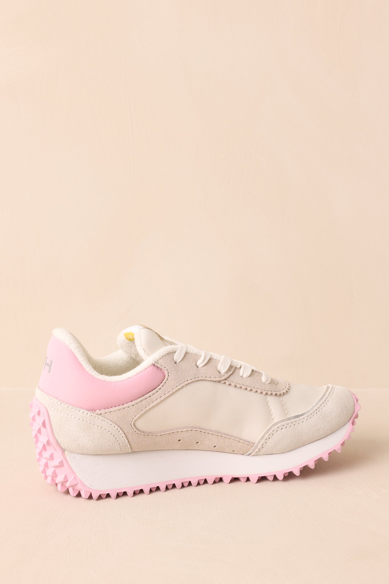 An angled back view of the shoes with a clear view of the smooth baby pink heel and subtle stitching on the upper panel.