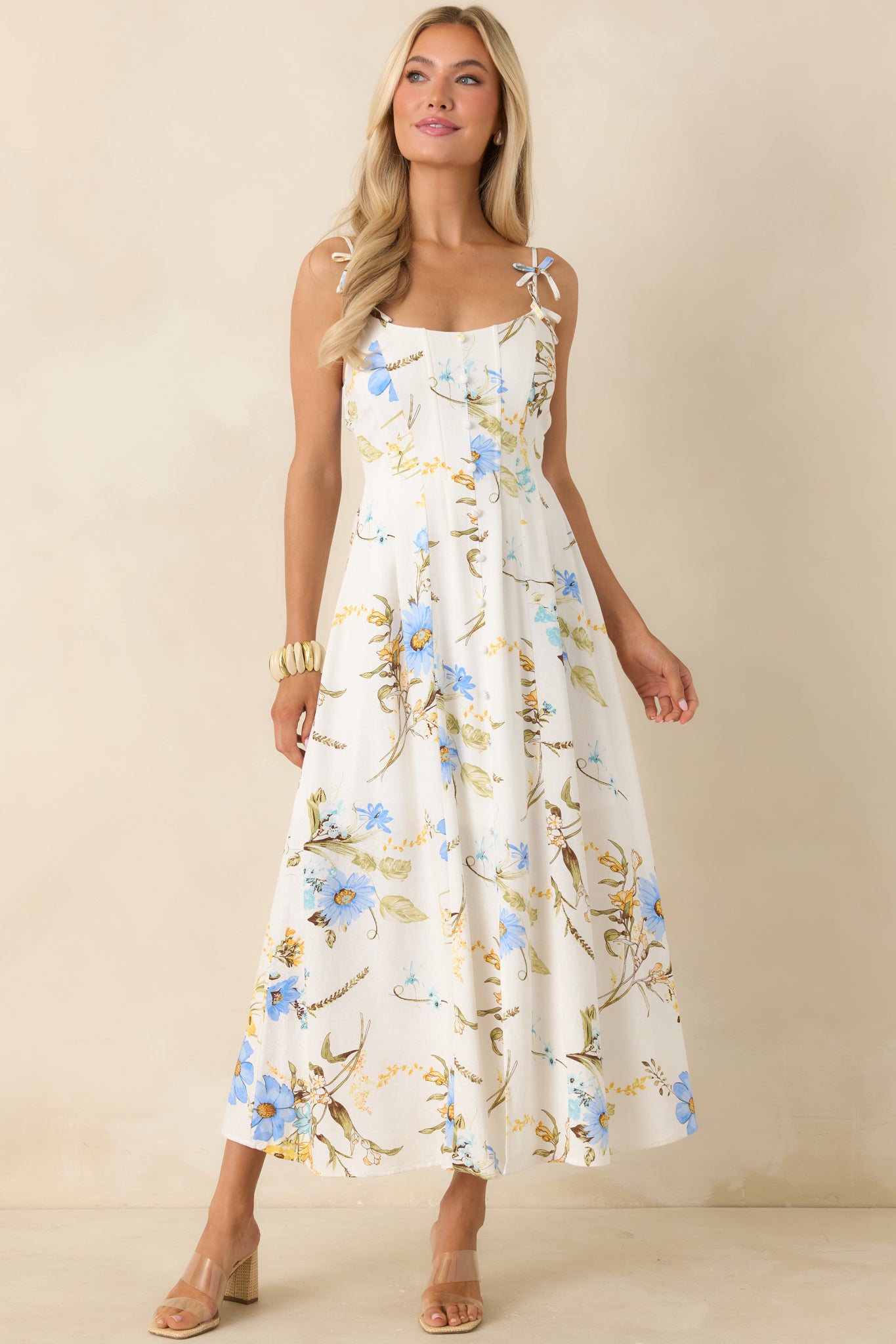 Floral midi dress in blue tones with warm golden accents, featuring a tailored bodice and fluid skirt for an airy finish.