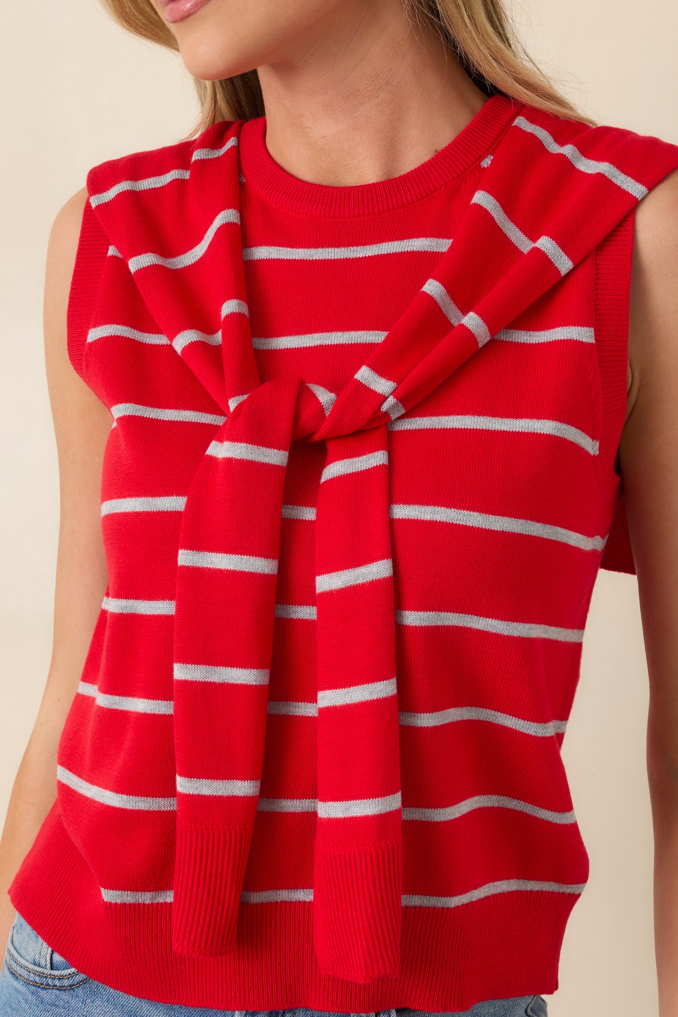 Detailed view of ribbed knit texture and draped scarf-style ties on the red striped sweater tank.