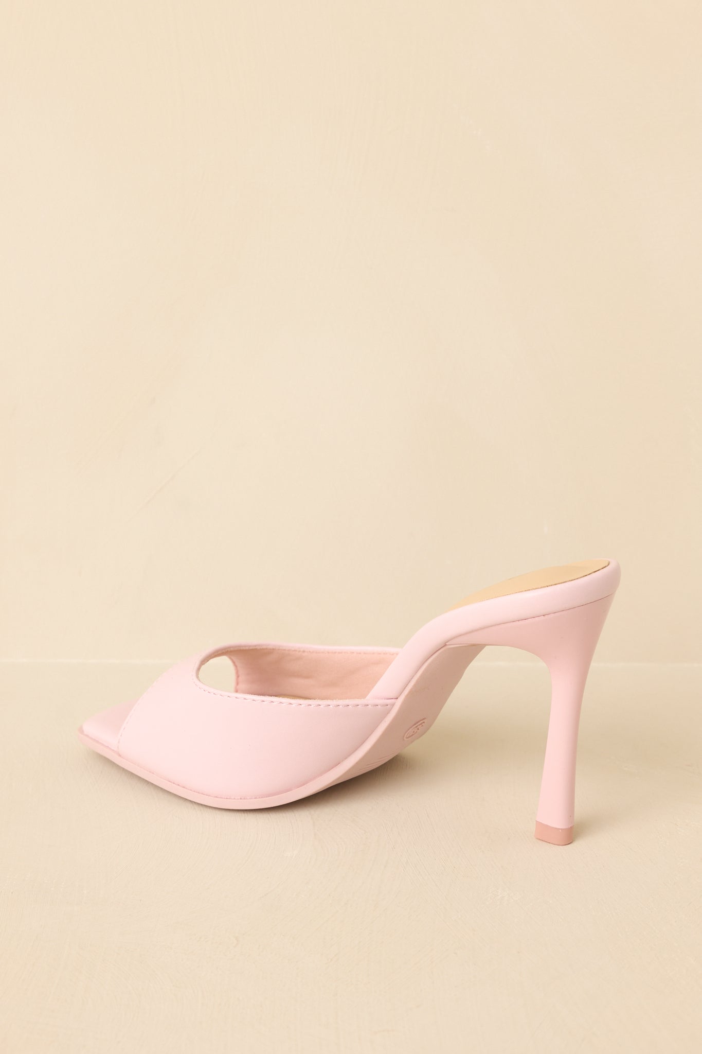Back view of pink mule heels showing open heel and slim high heel design.