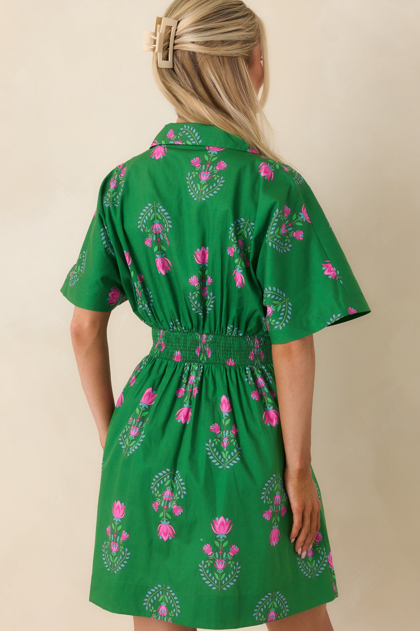 Rear view of the mini dress with smocked elastic waist panel and short sleeves.