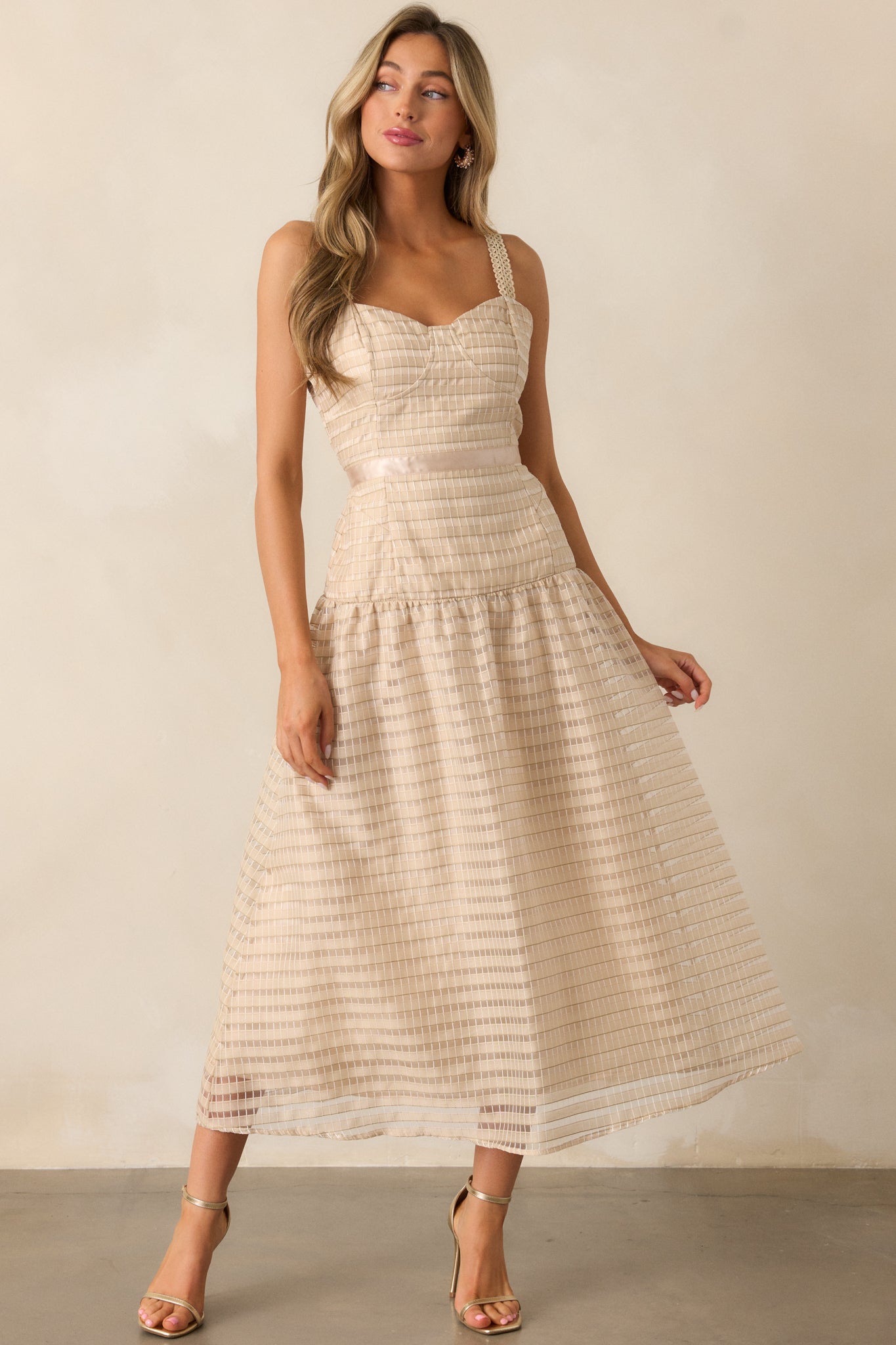 The drop waist silhouette accentuates the shape, with delicate embroidery cascading through the airy, voluminous skirt.