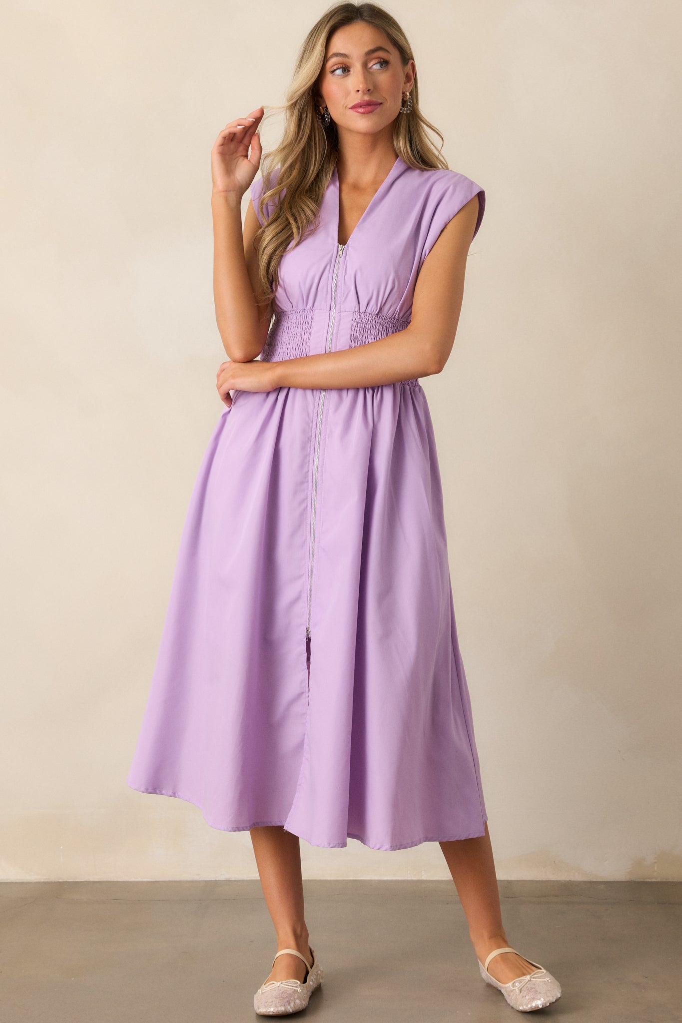 This lavender midi dress offers a full zipper front, functional hip pockets, and a fully smocked waist for a comfortable, chic fit.
