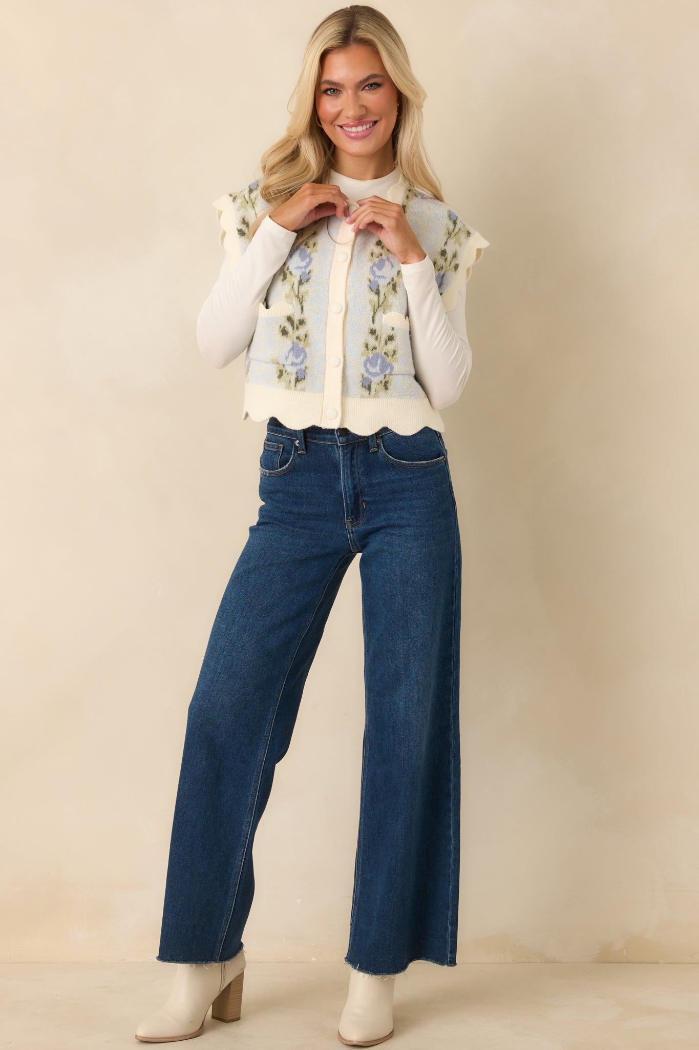 Full view of the vest showcasing the decorative front patch pockets and ribbed detailing on the light blue knit.