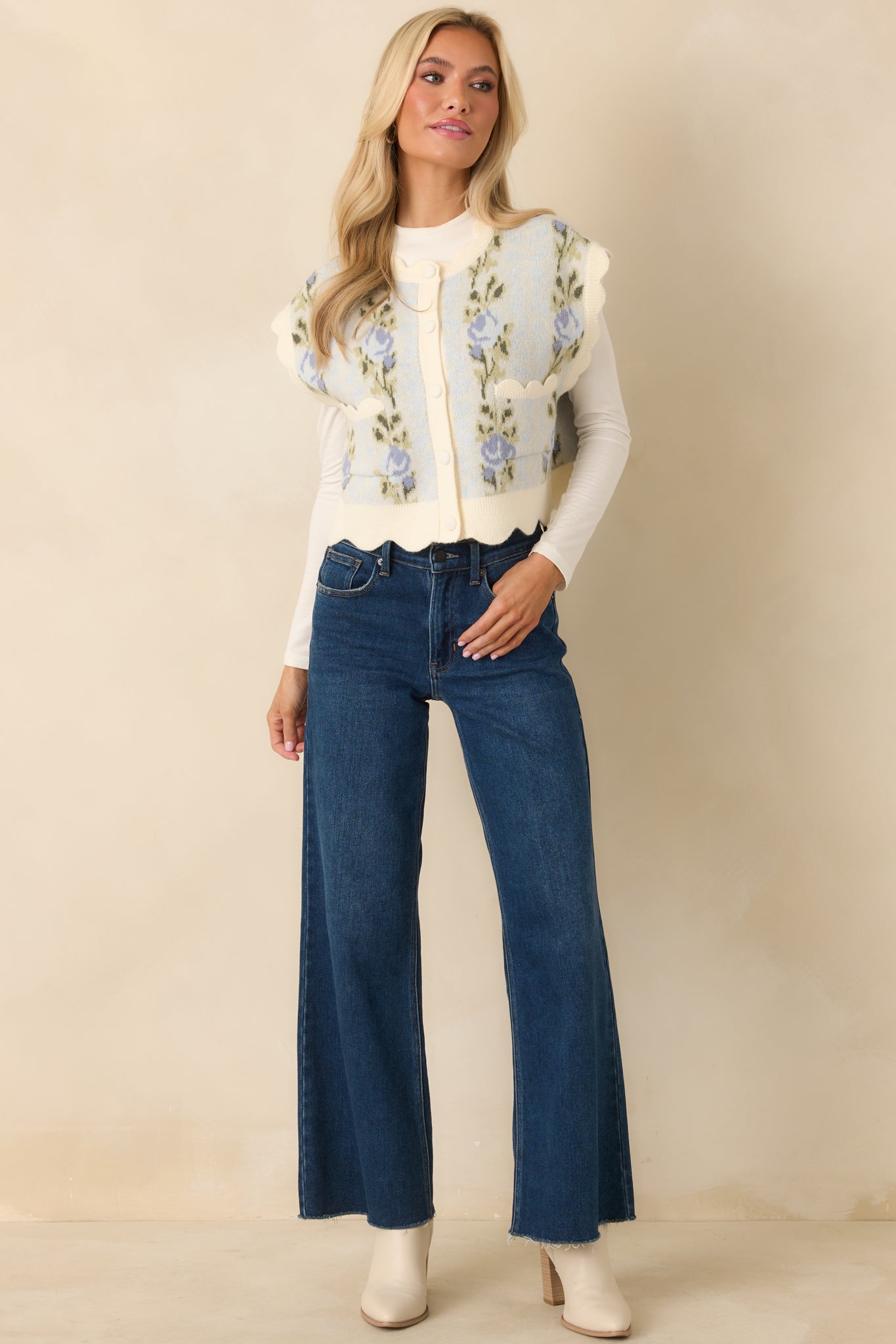 Full front view of the light blue knit vest featuring a cropped silhouette, allover floral pattern, and button-front closure.