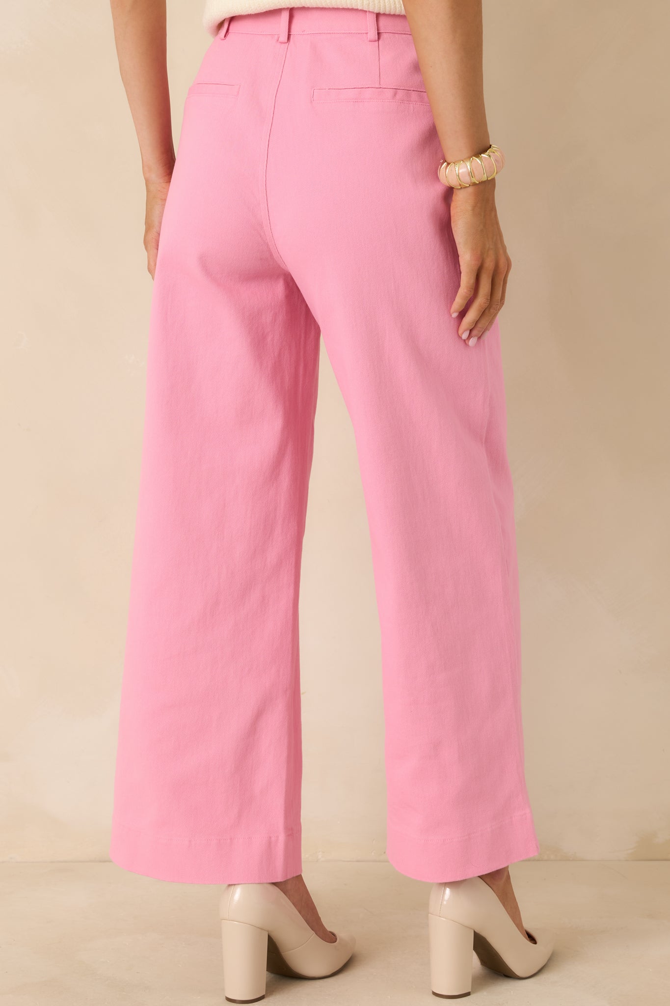 Rear photo of pink cotton pants featuring tailored welt pockets and a smooth, structured breathable woven finish.