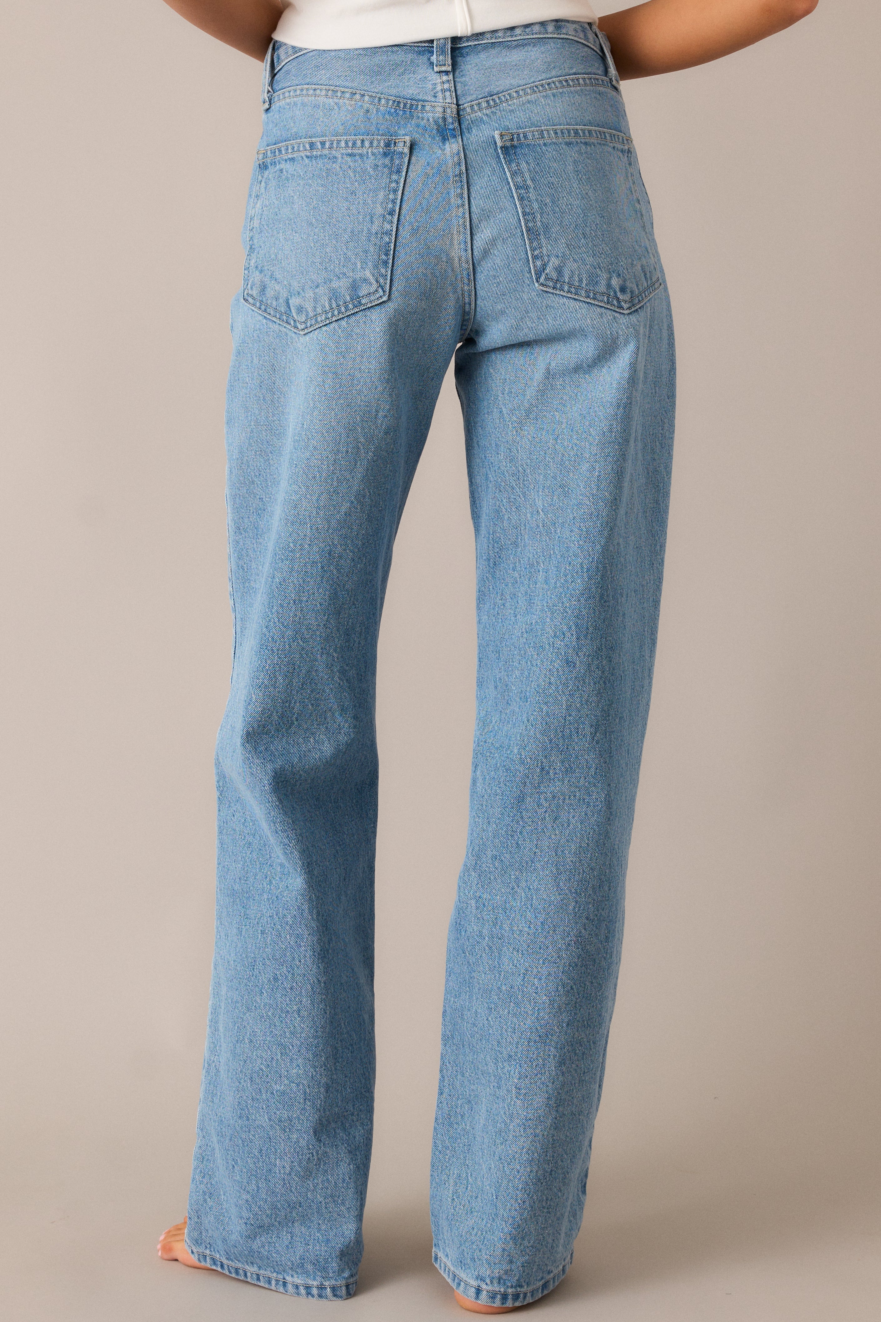 Rear view of light wash jeans highlighting relaxed fit, high waist, and back pocket details.