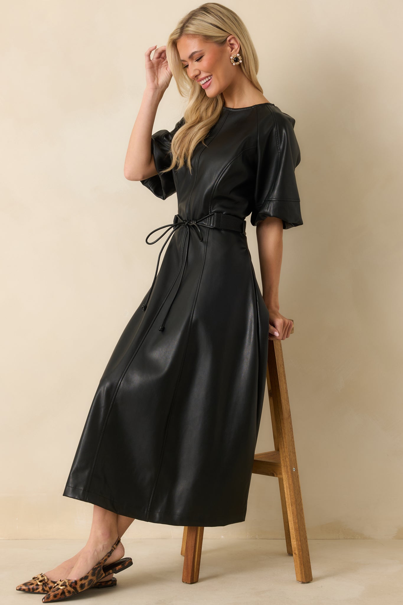 Black faux leather dress with an adjustable waist tie creating a customizable, defined shape