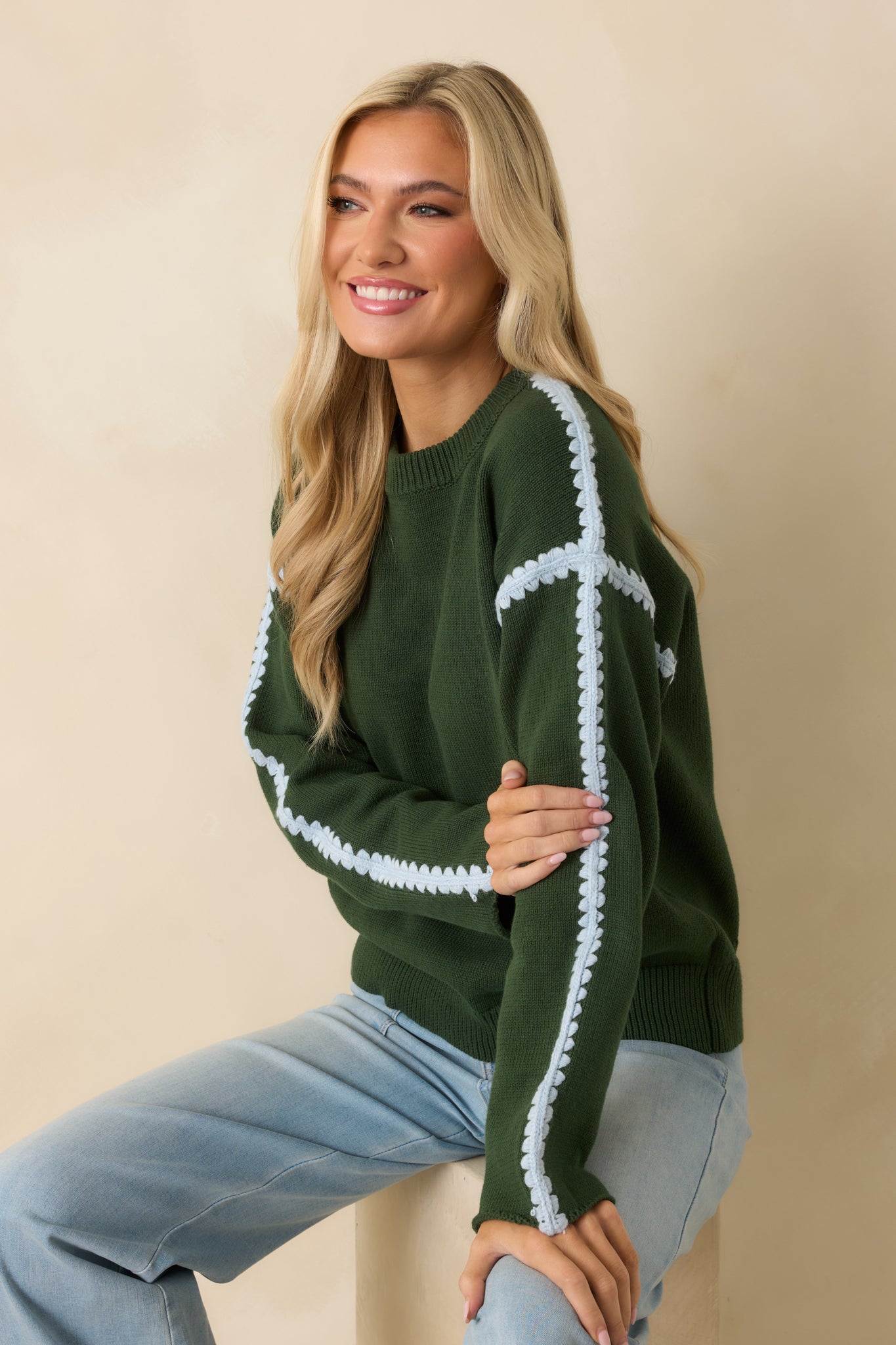 Long sleeve design with contrast crochet accents adding texture to the moss green knit.