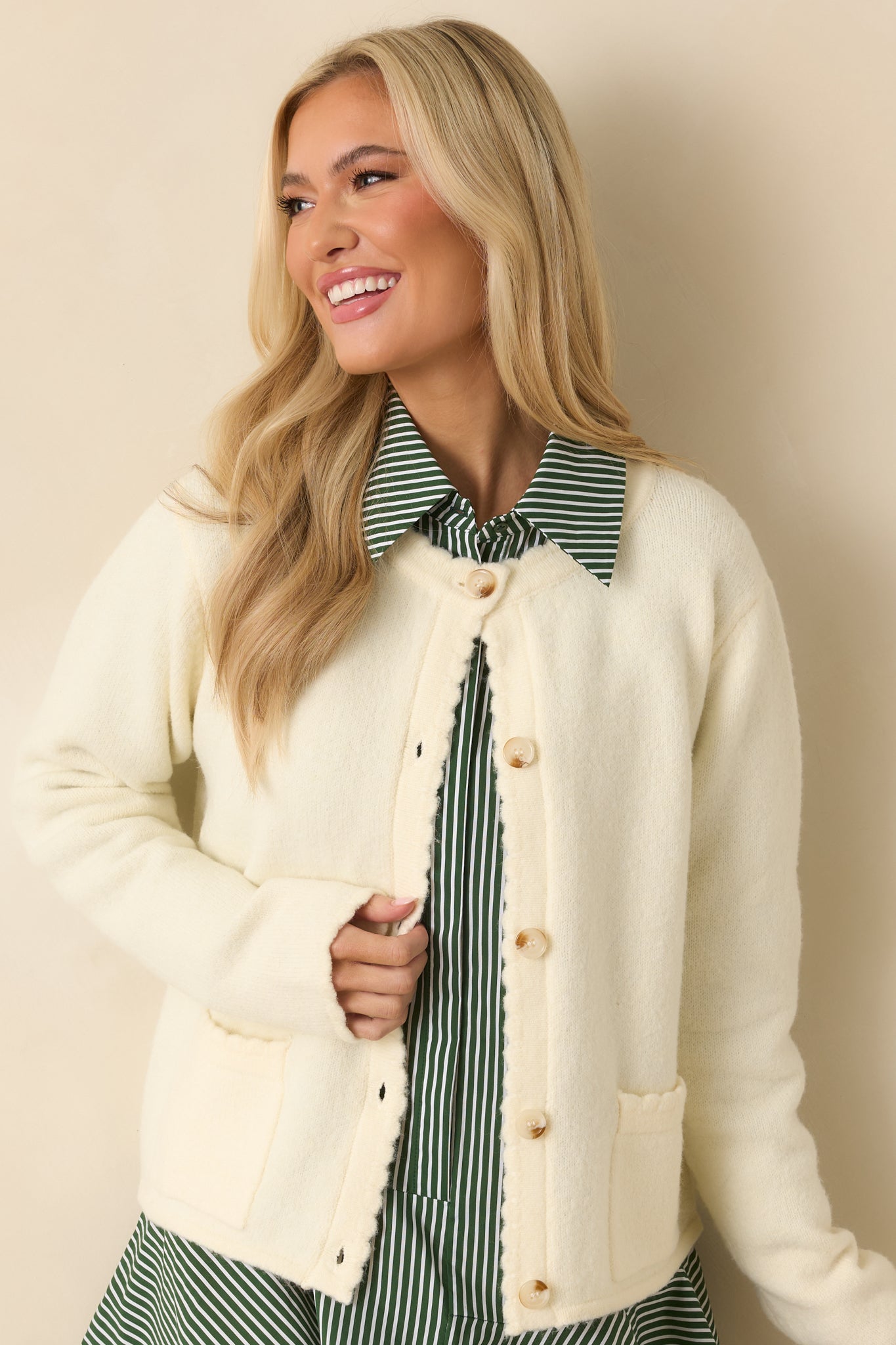 Ivory knit cardigan with a soft texture, long sleeves, and a classic button-front design featuring tortoise shell buttons.