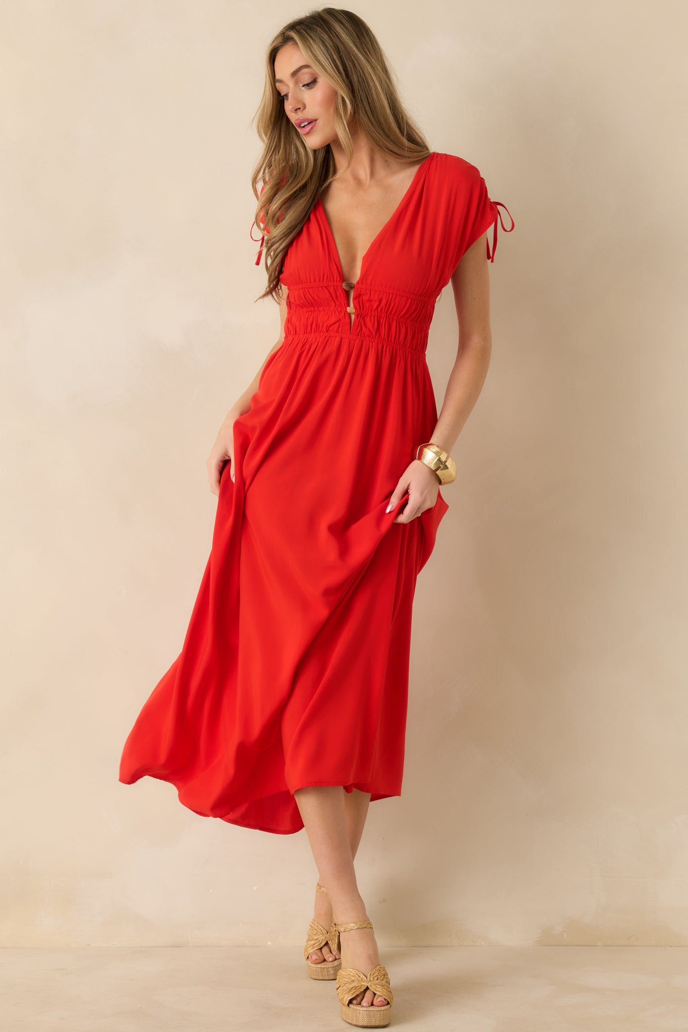 Bold red midi dress showing the defined waist and soft flowing midi-length silhouette.