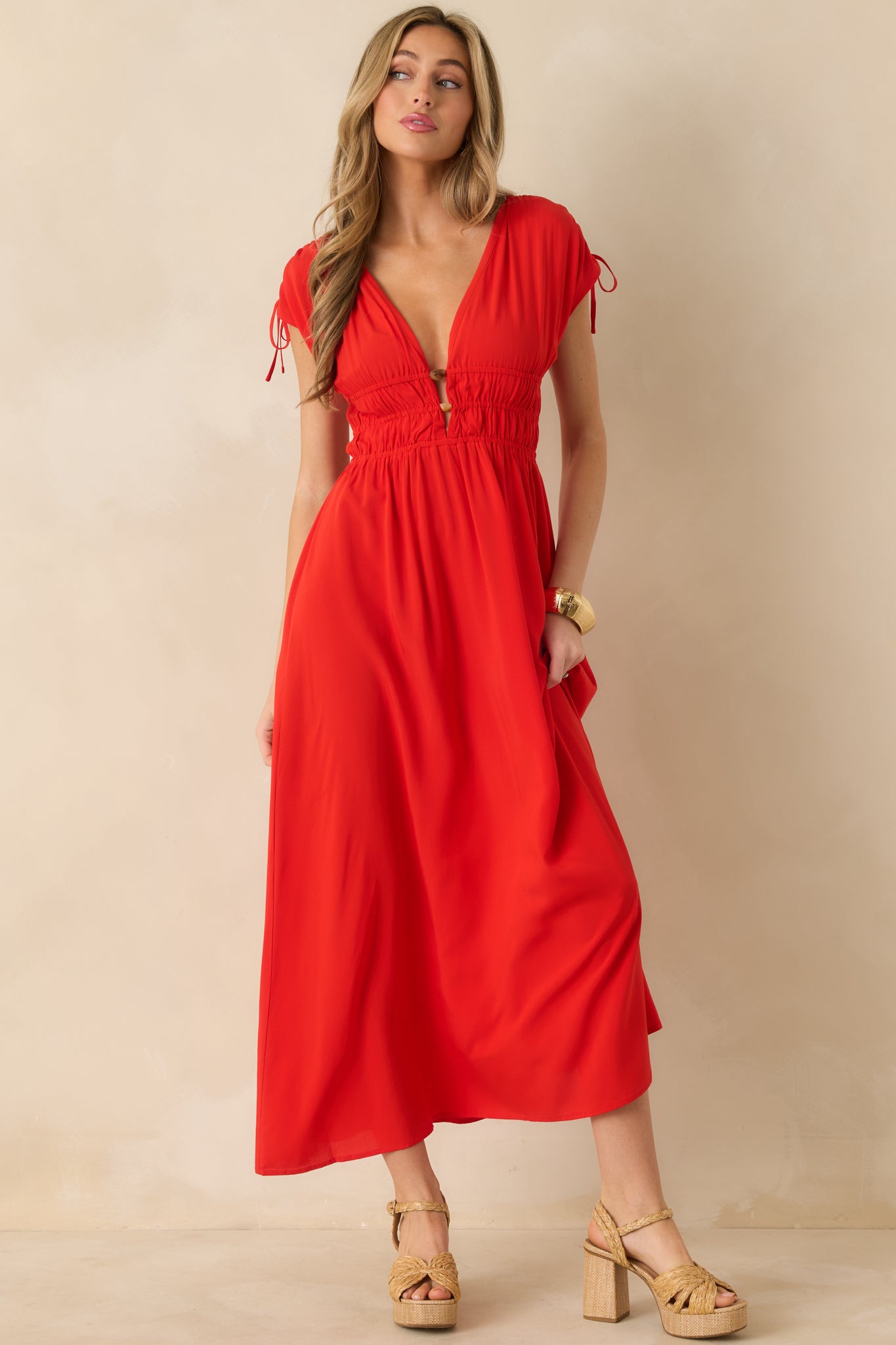 V-neck red midi dress emphasizing the beaded neckline and airy flutter sleeves.