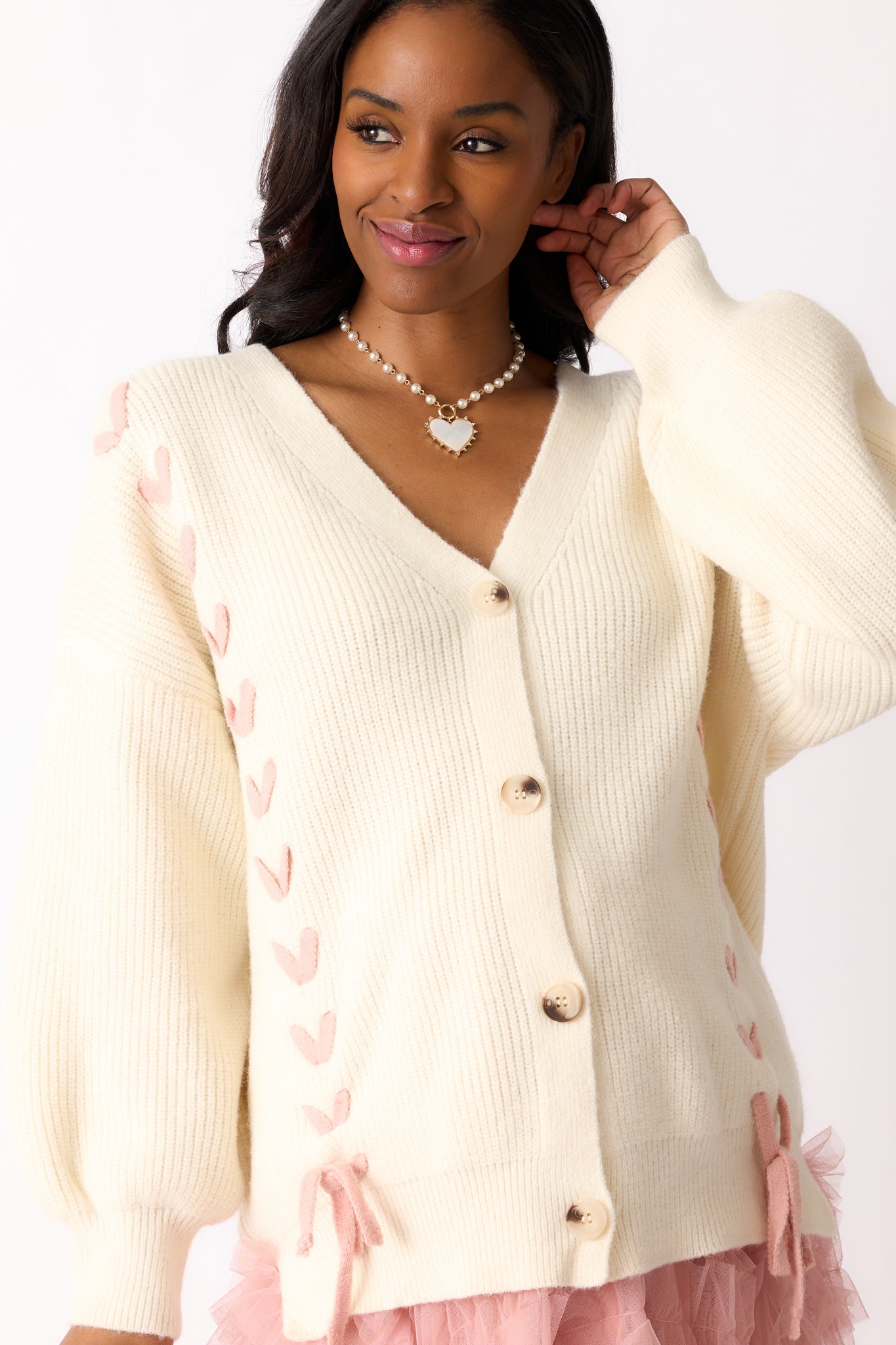 A close-up of the v-neckline and upper buttons, focusing on the stitch detailing and texture of the cardigan.