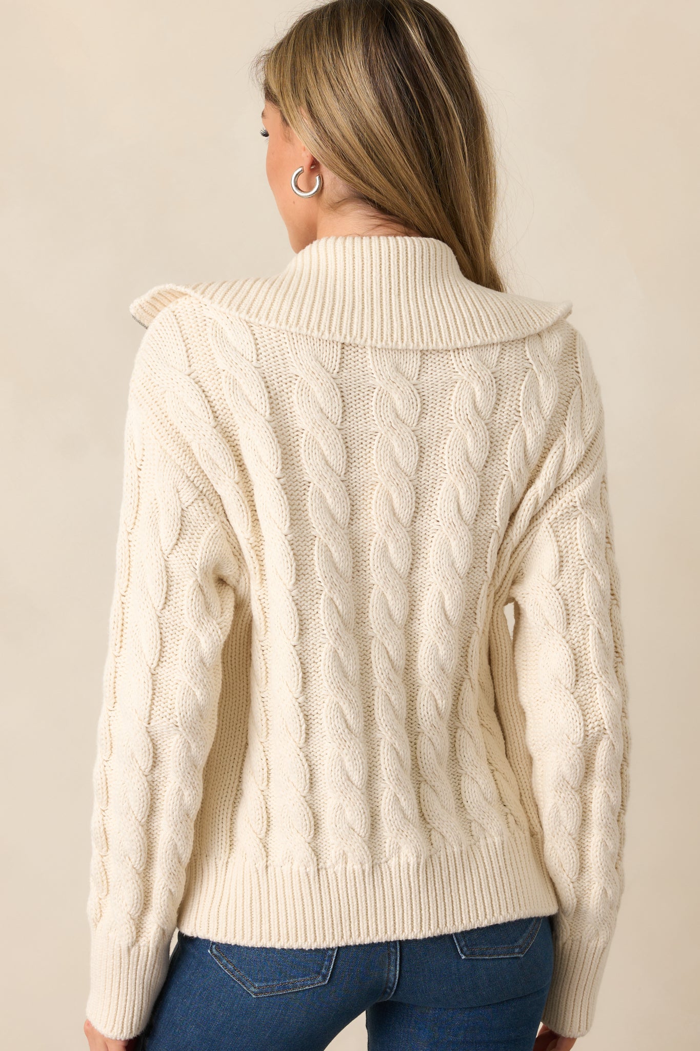 The back of the ivory seasalt cardigan, featuring a seamless cable knit design and the oversized collar continuing the cozy style.