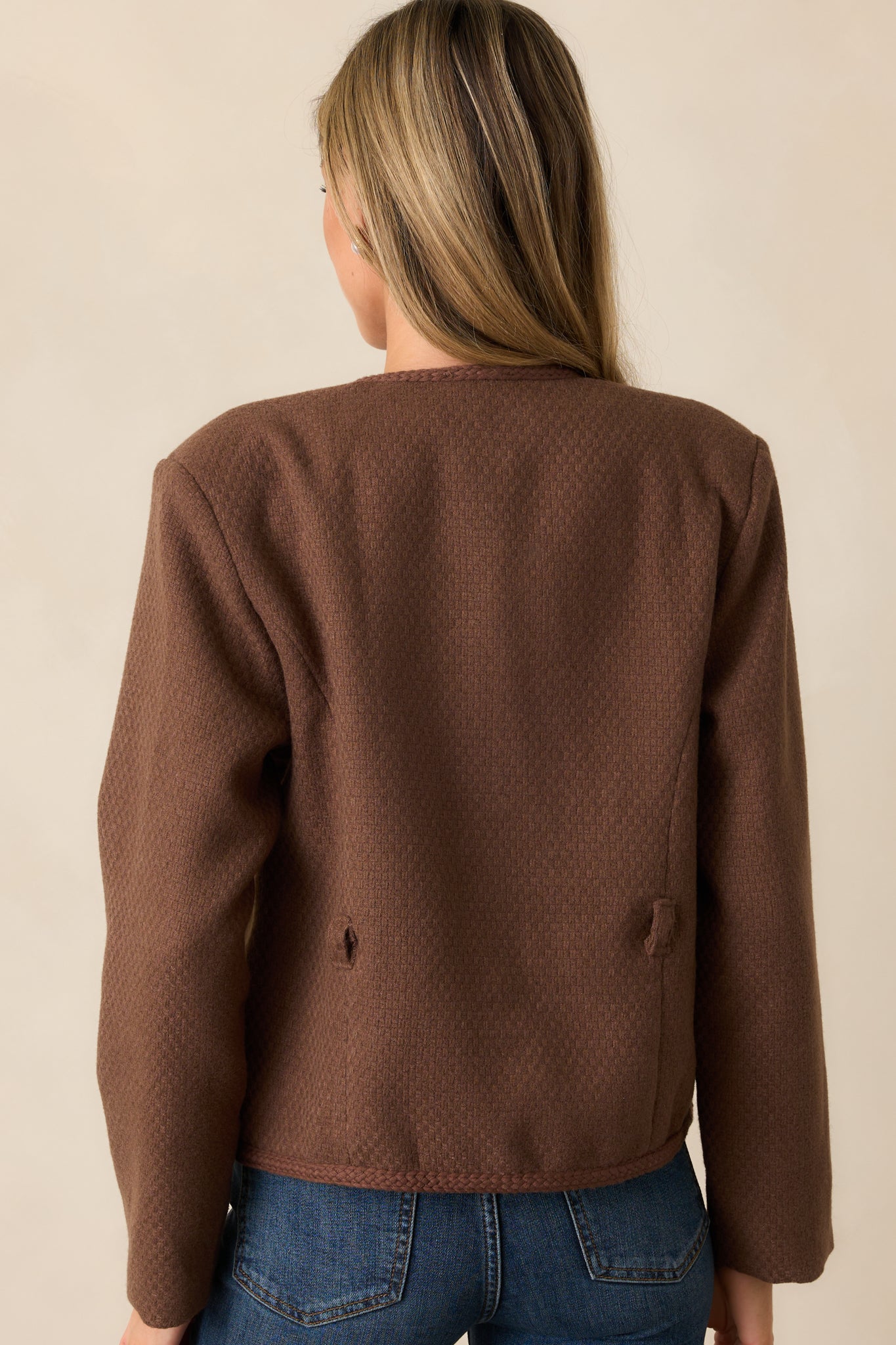 Another back view of the chocolate brown jacket highlighting the tailored fit, tweed fabric, and braided trim running along the edges.
