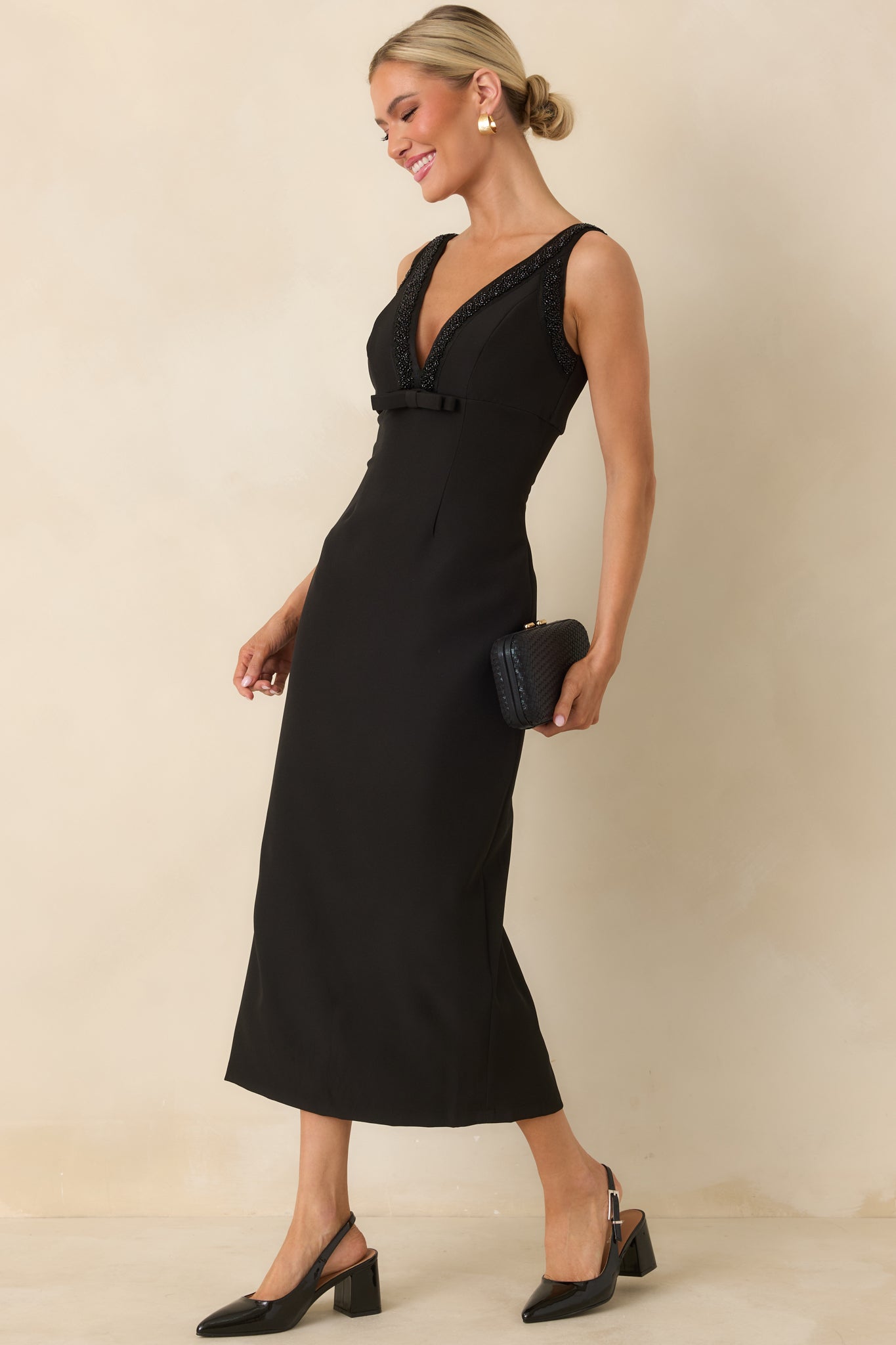 Black structured midi dress with sleeveless cut, deep V-neckline, and subtle beaded accents along the front.
