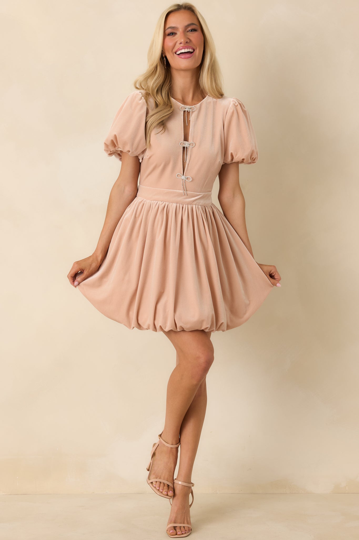 Velvet blush dress with a gentle sheen, structured puff sleeves, and a softly gathered skirt.