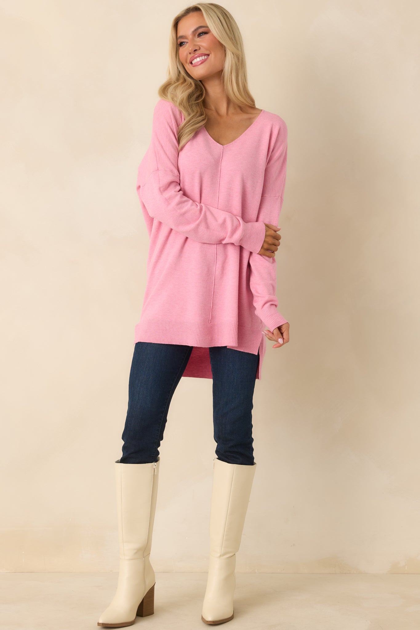 Bubblegum pink knit sweater with a lightweight feel, long sleeves, and a V-neckline in a relaxed longline fit.