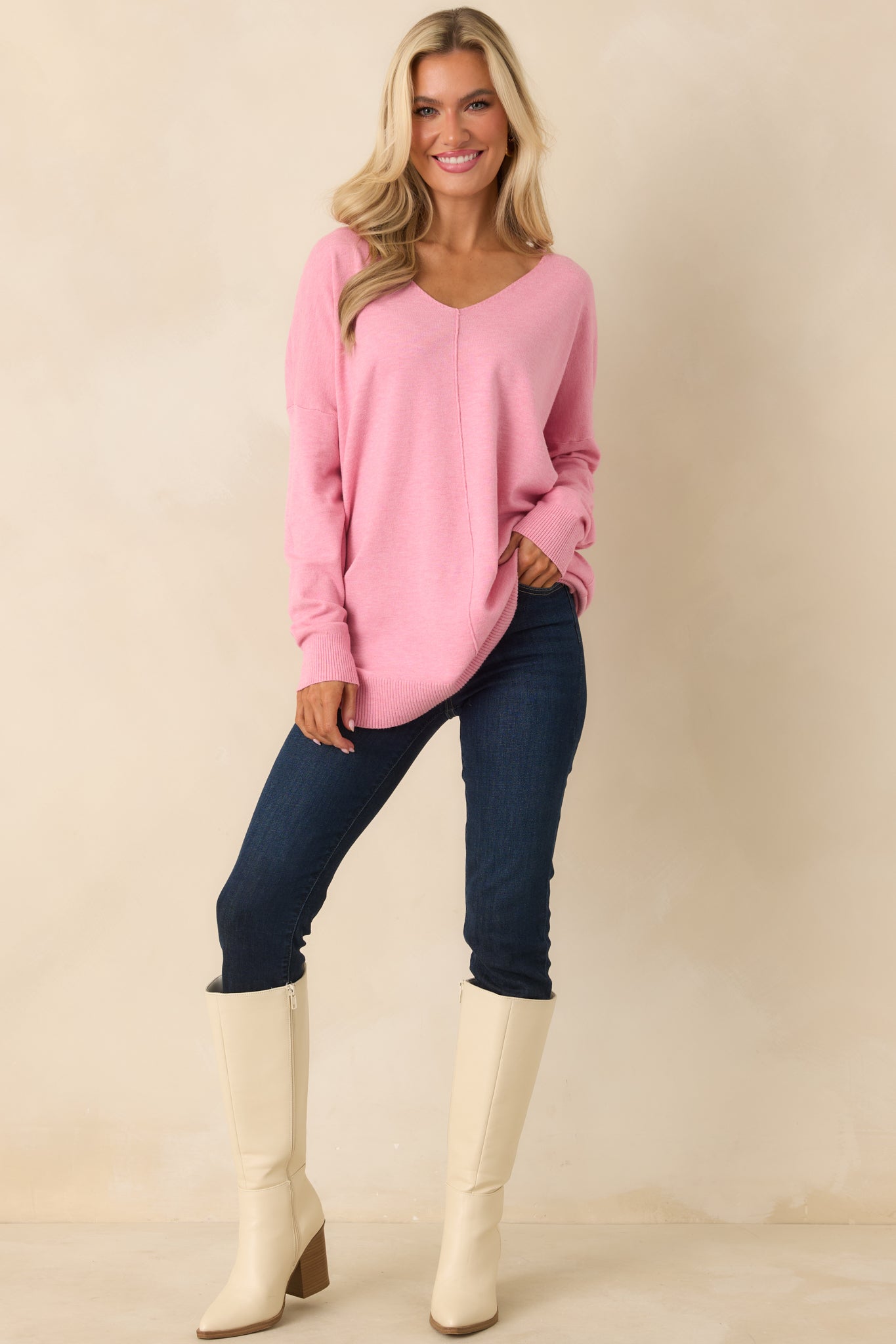 Bubblegum pink knit sweater designed with a V-neckline, long sleeves, and clean vertical knit ribbing for gentle texture.