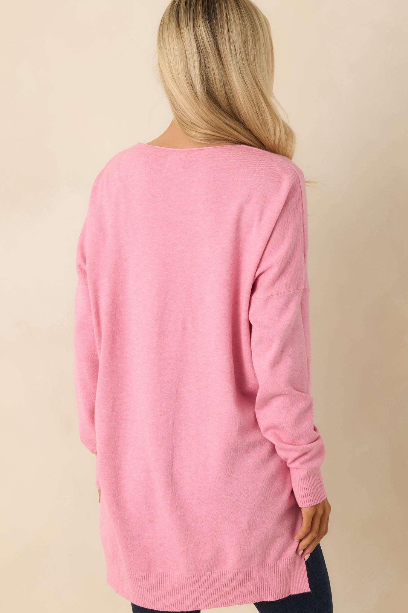 Rear of the bubblegum pink knit sweater featuring a relaxed back panel and a slightly longer hemline for soft drape.