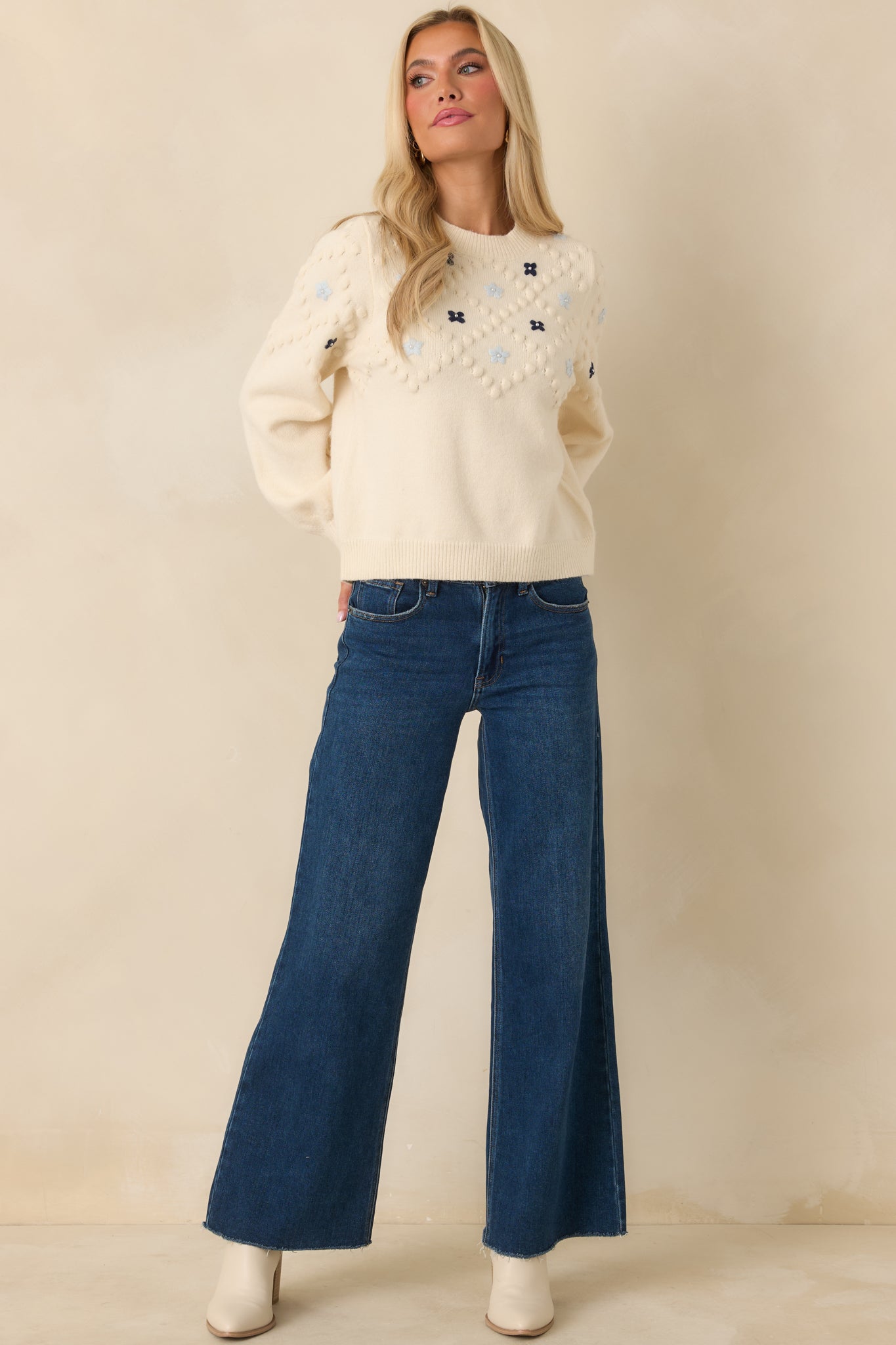Textured ivory knit sweater featuring bobble detailing throughout and vibrant floral embroidery centered on the front.