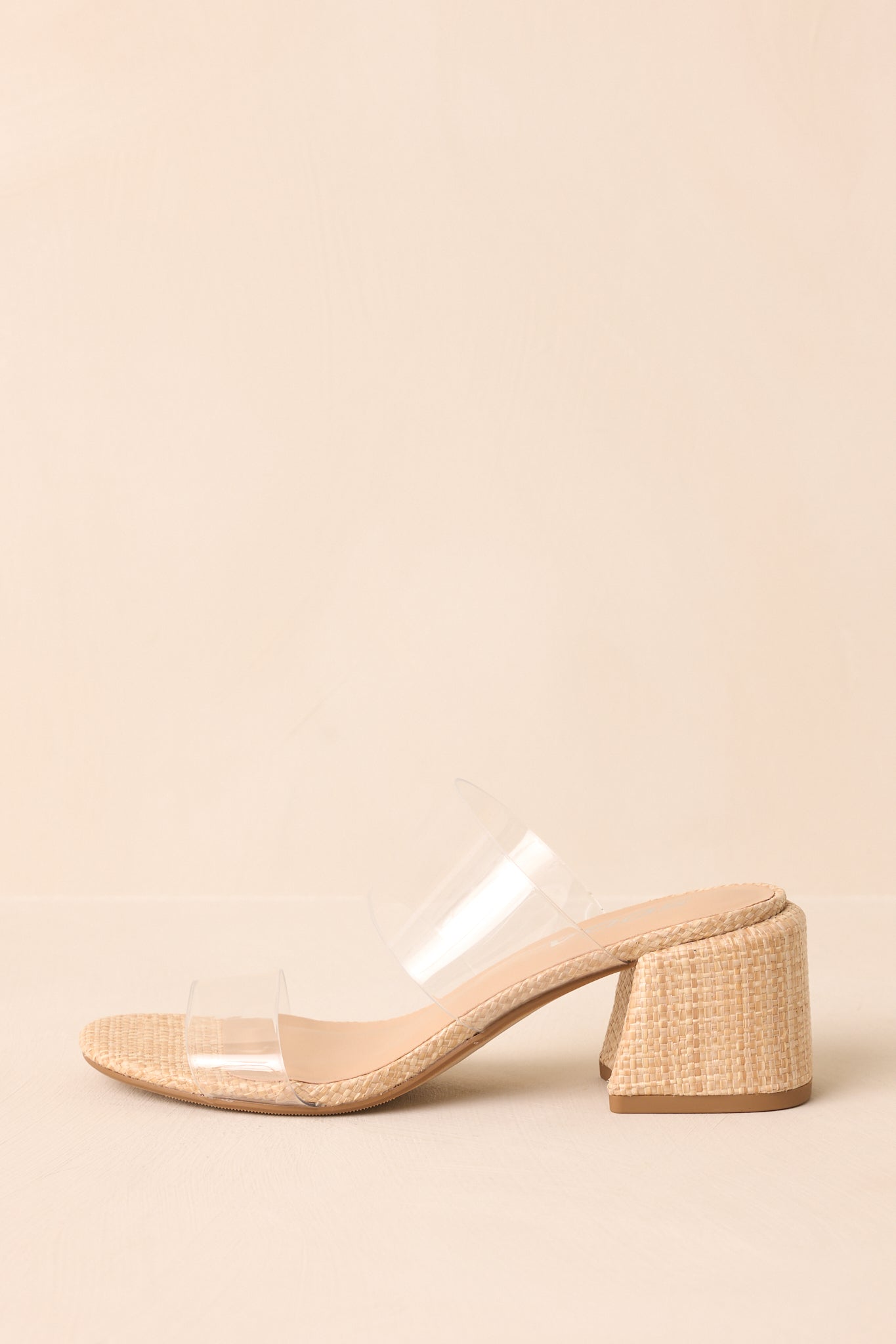 A zoomed-in side image of the short block heel and natural raffia sole, highlighting the woven texture.