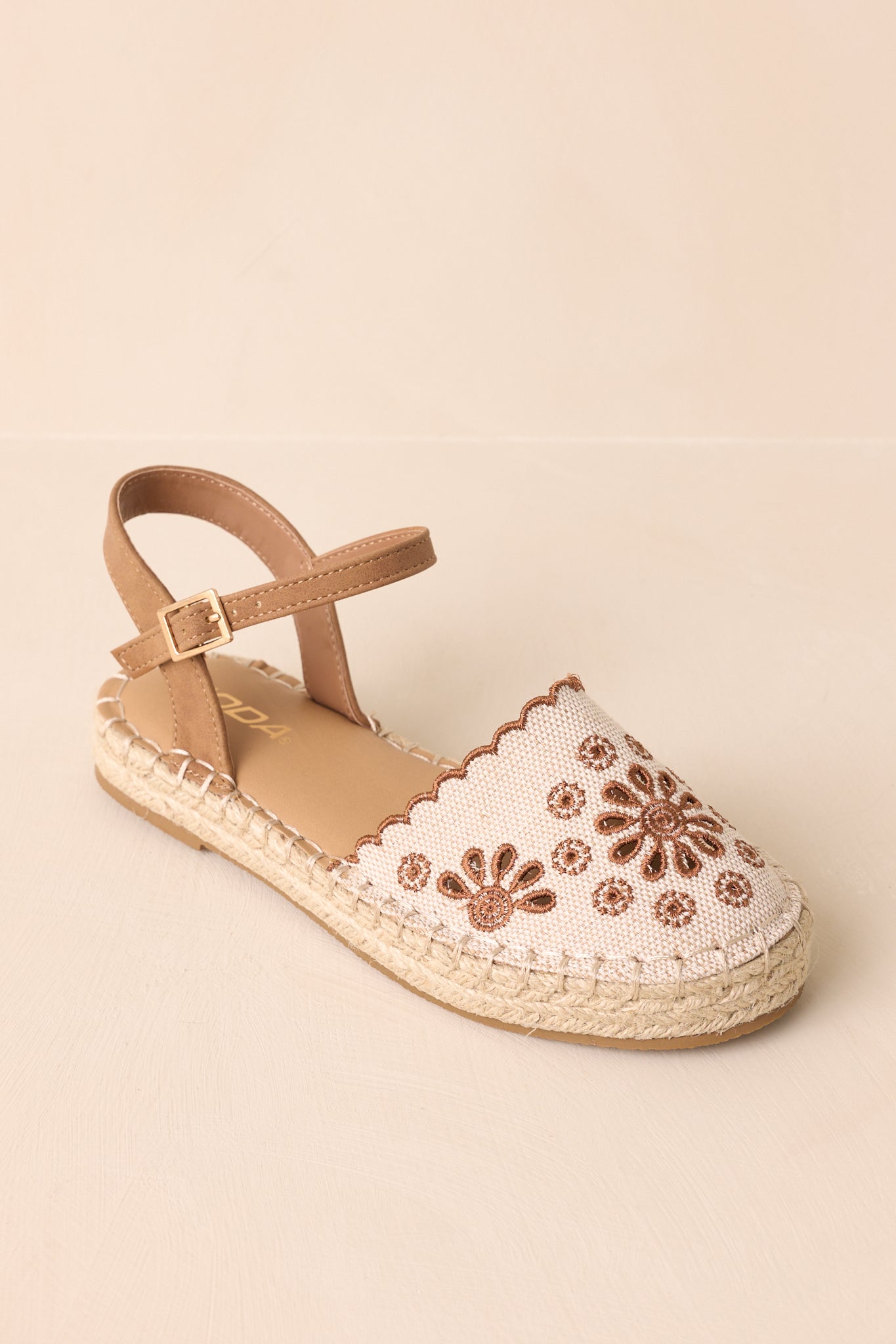Overhead view of the sandals emphasizing the embroidered toe and woven texture of the sole.