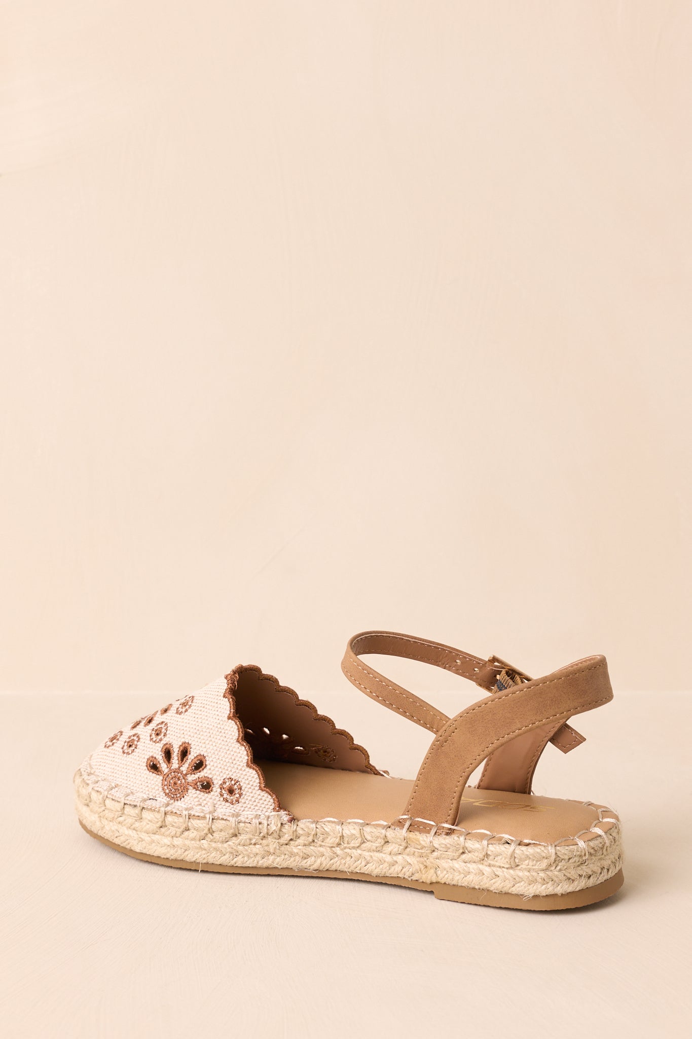 Back view of the sandals showing the brown faux leather ankle straps, gold buckles, and heel edge of the jute sole.