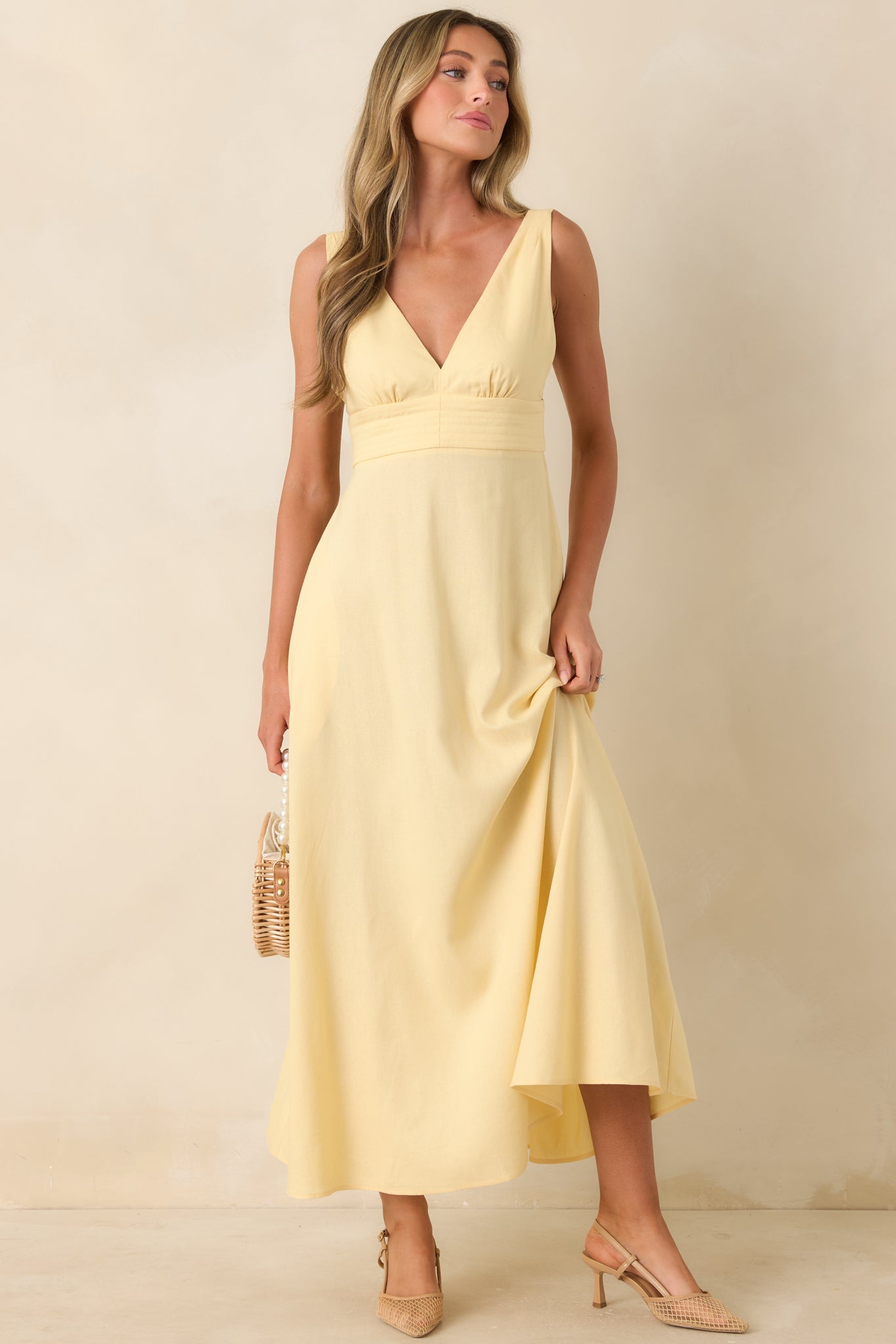 Structured midi dress with deep V-neckline and sweeping skirt movement.