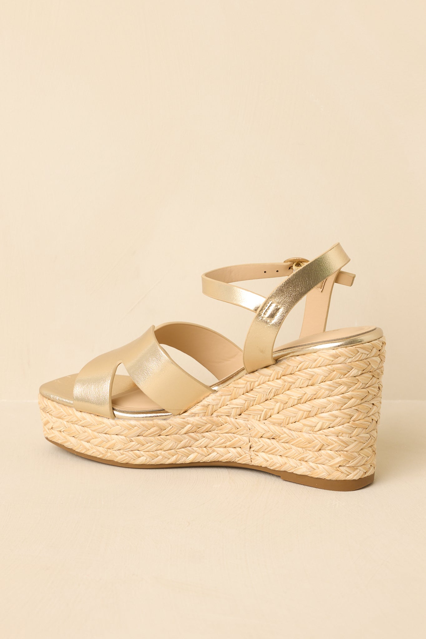 Back view of wedge sandals featuring an adjustable ankle strap with buckle closure and woven espadrille wedge heel.