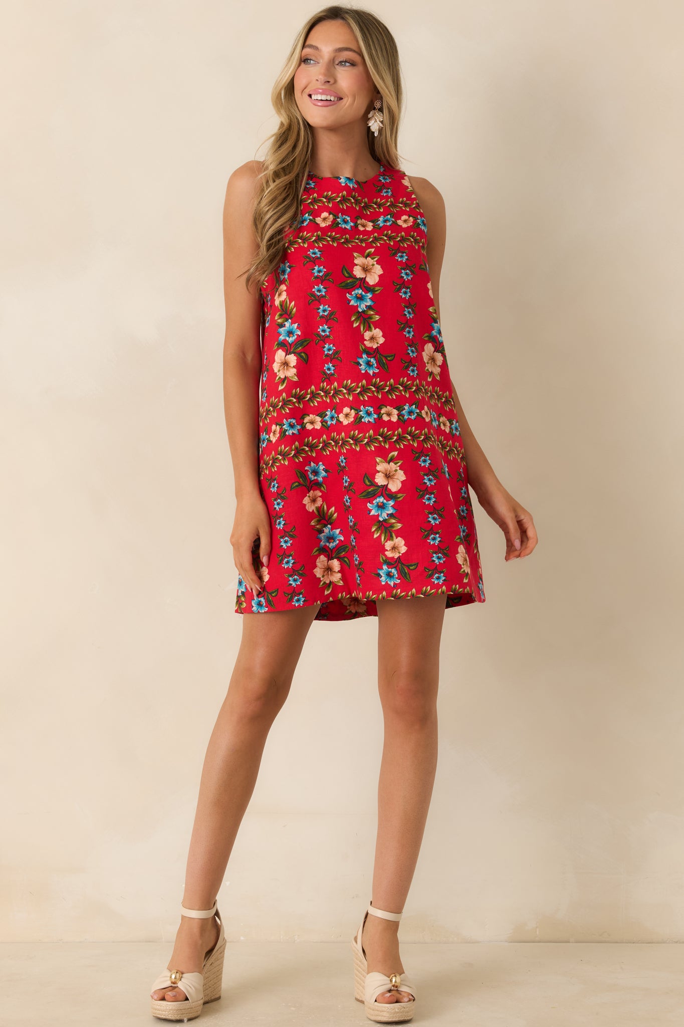 Red floral mini dress with a round neckline, clean sleeveless design, and soft structured drape.