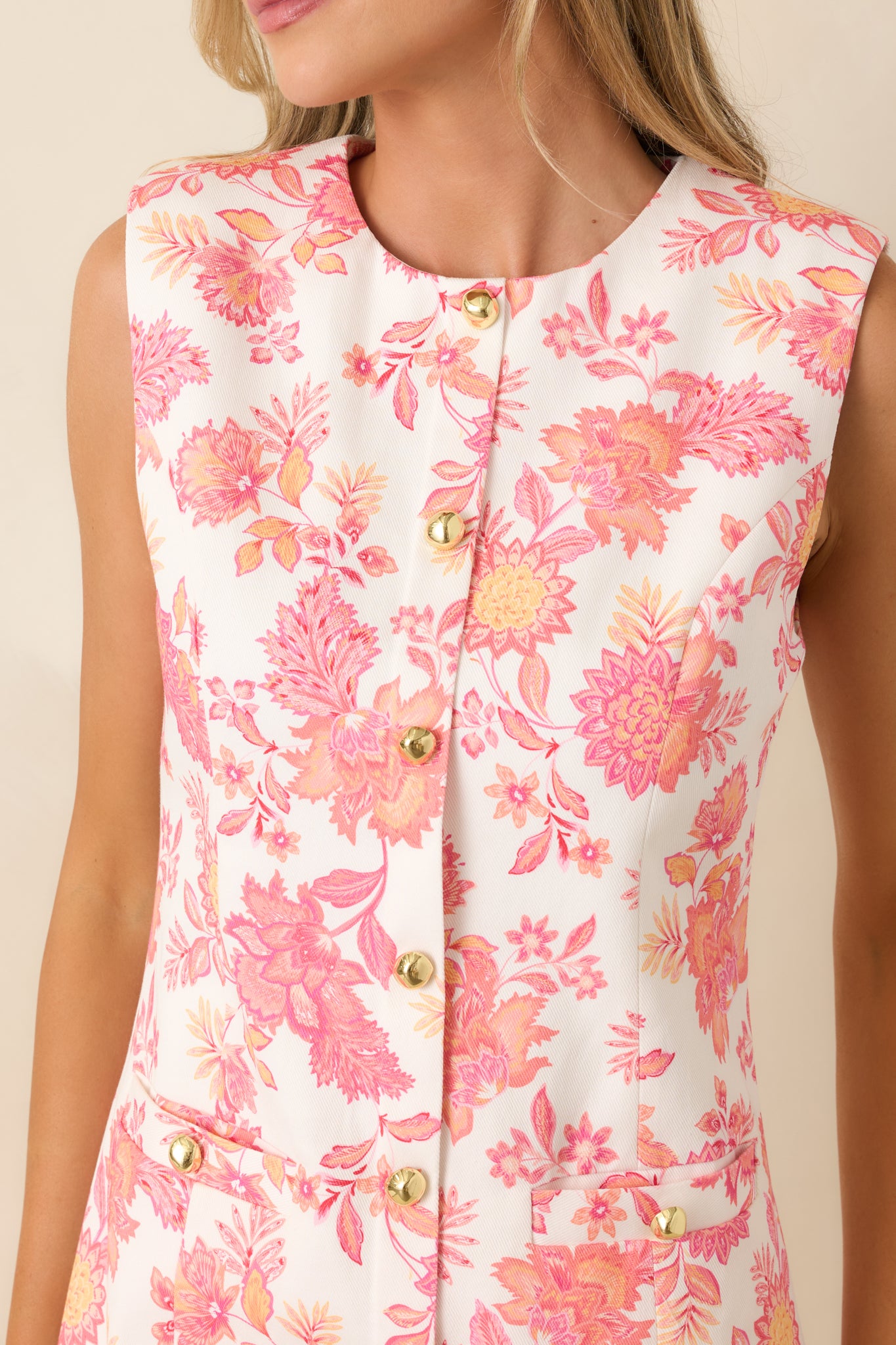 Coral floral fabric with gold-tone buttons and faux welt pocket detail.