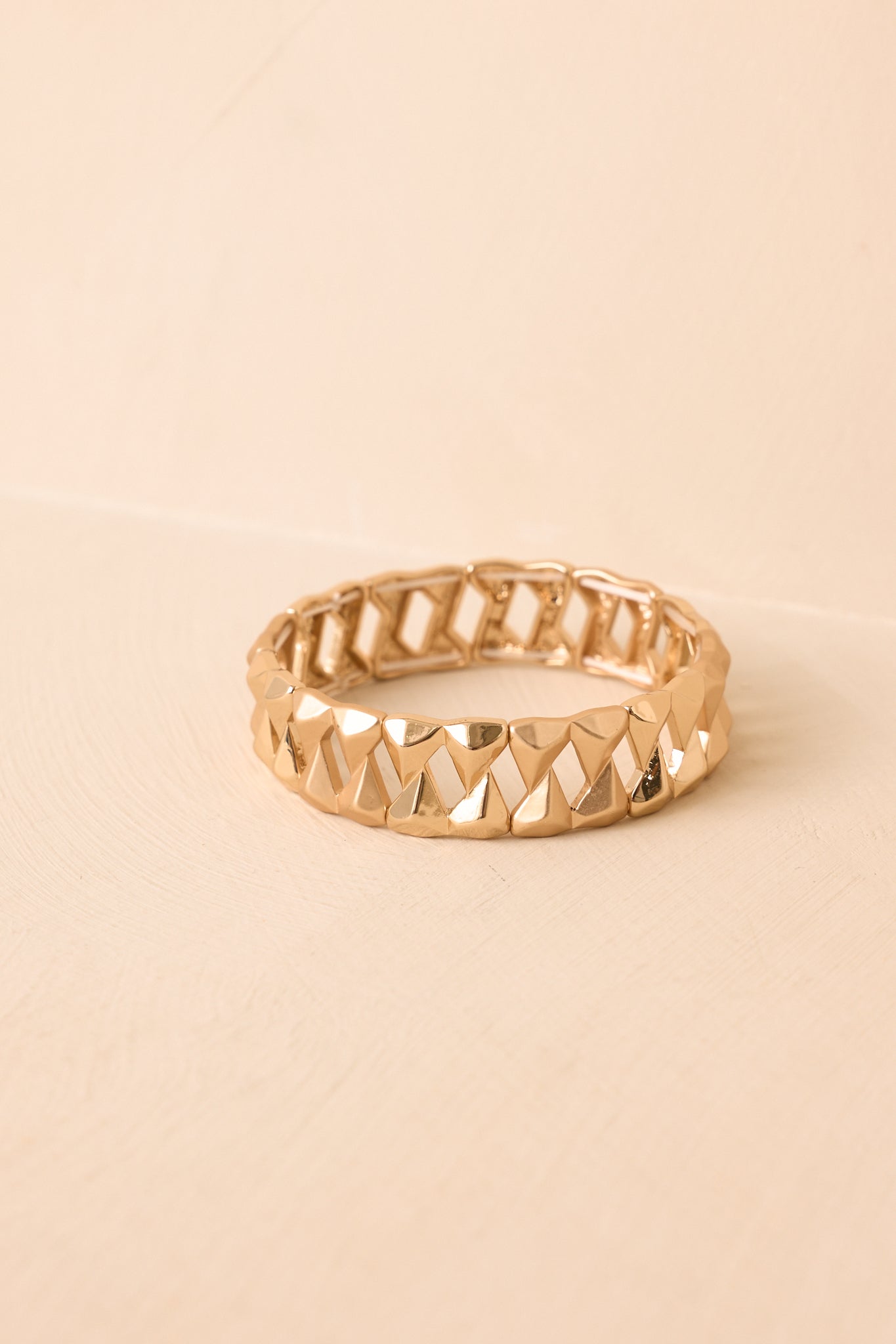 Detailed close-up of gold bracelet highlighting faceted geometric links, textured finish, and elastic stretch band construction.