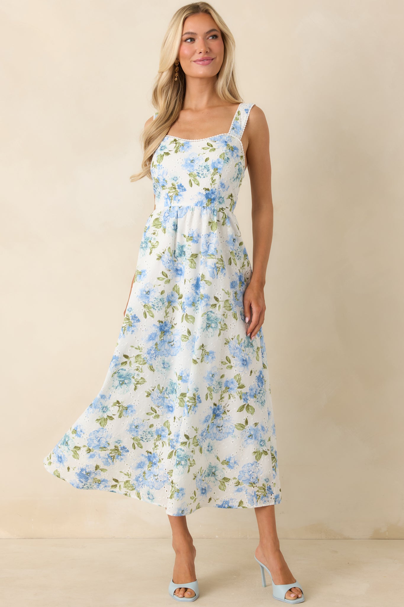 Blue and white midi dress featuring intricate eyelet design and soft, feminine drape.