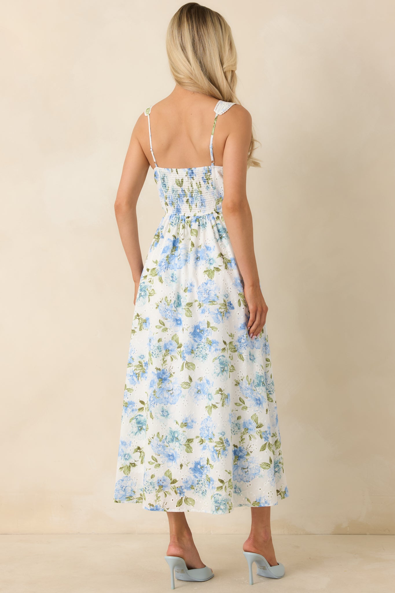 Rear view of blue and white midi dress with smocked back panel and adjustable straps.