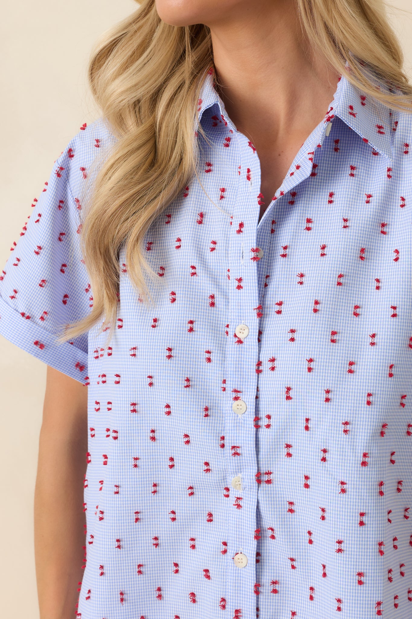 Close-up of the blue gingham fabric showcasing the textured red tufted embroidery and lightweight cotton construction.