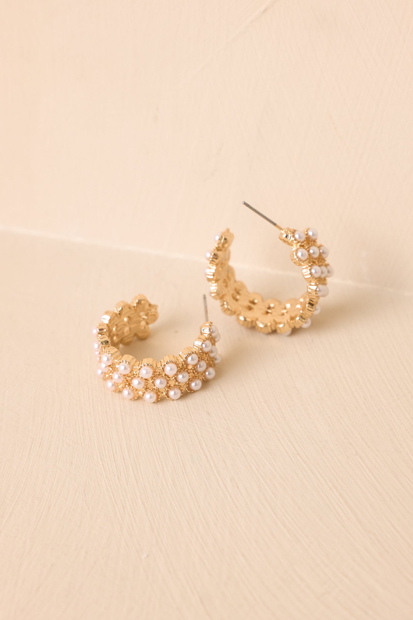Textured gold-tone hoop earrings with clustered faux pearl embellishments and secure post-back closures.