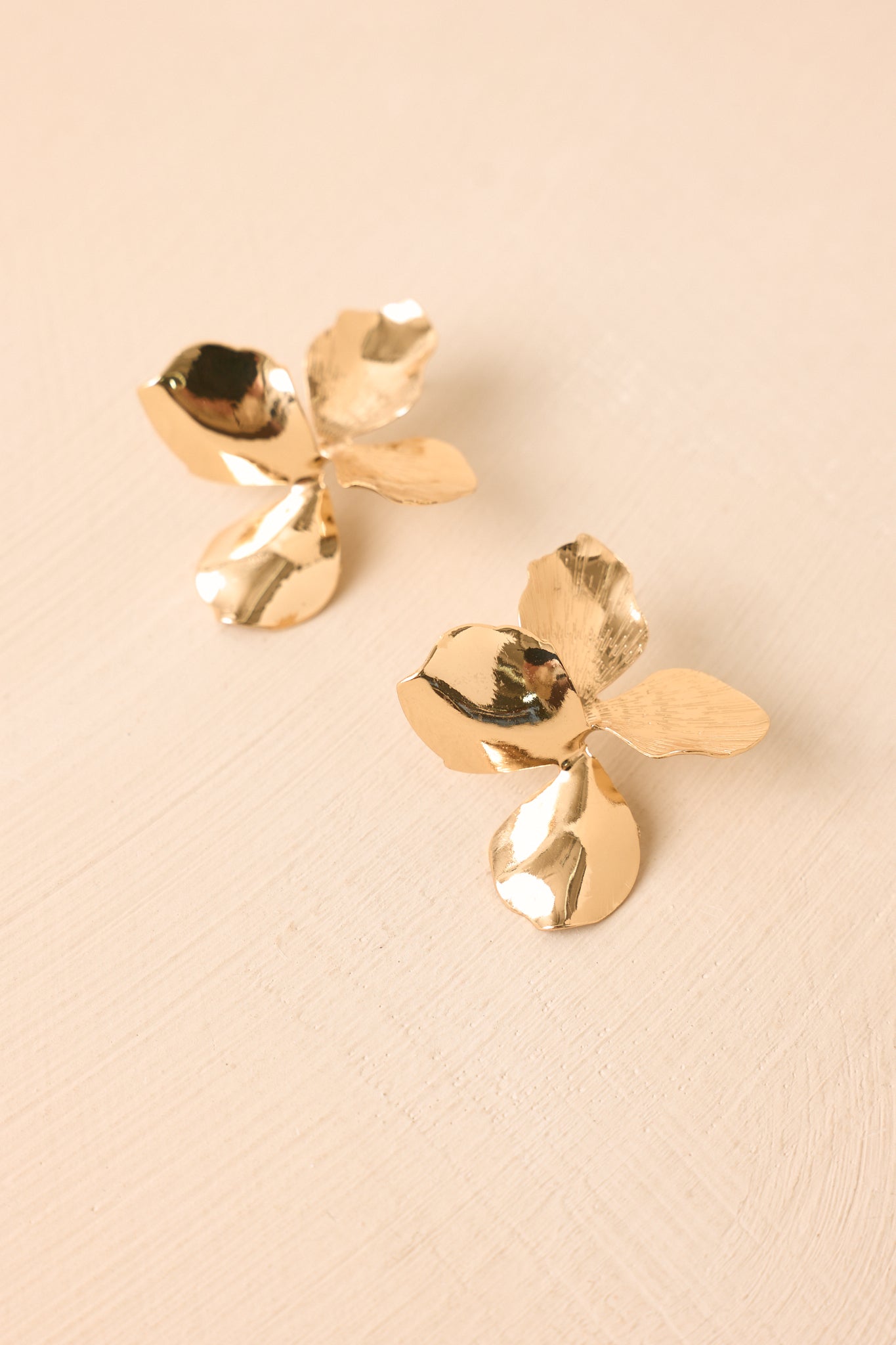 Botanical-inspired gold earrings showcasing dimensional flower details, textured petals, and a bold yet refined design.